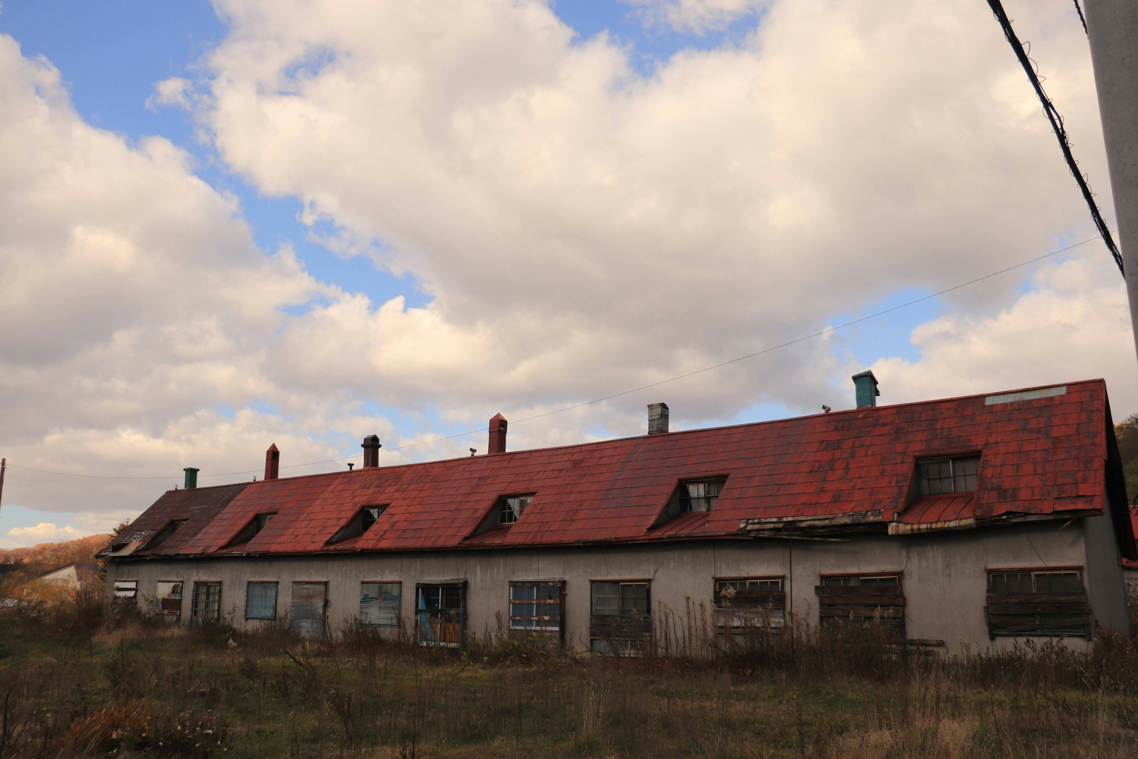 Row of old buildings with red roofs under a cloudy sky