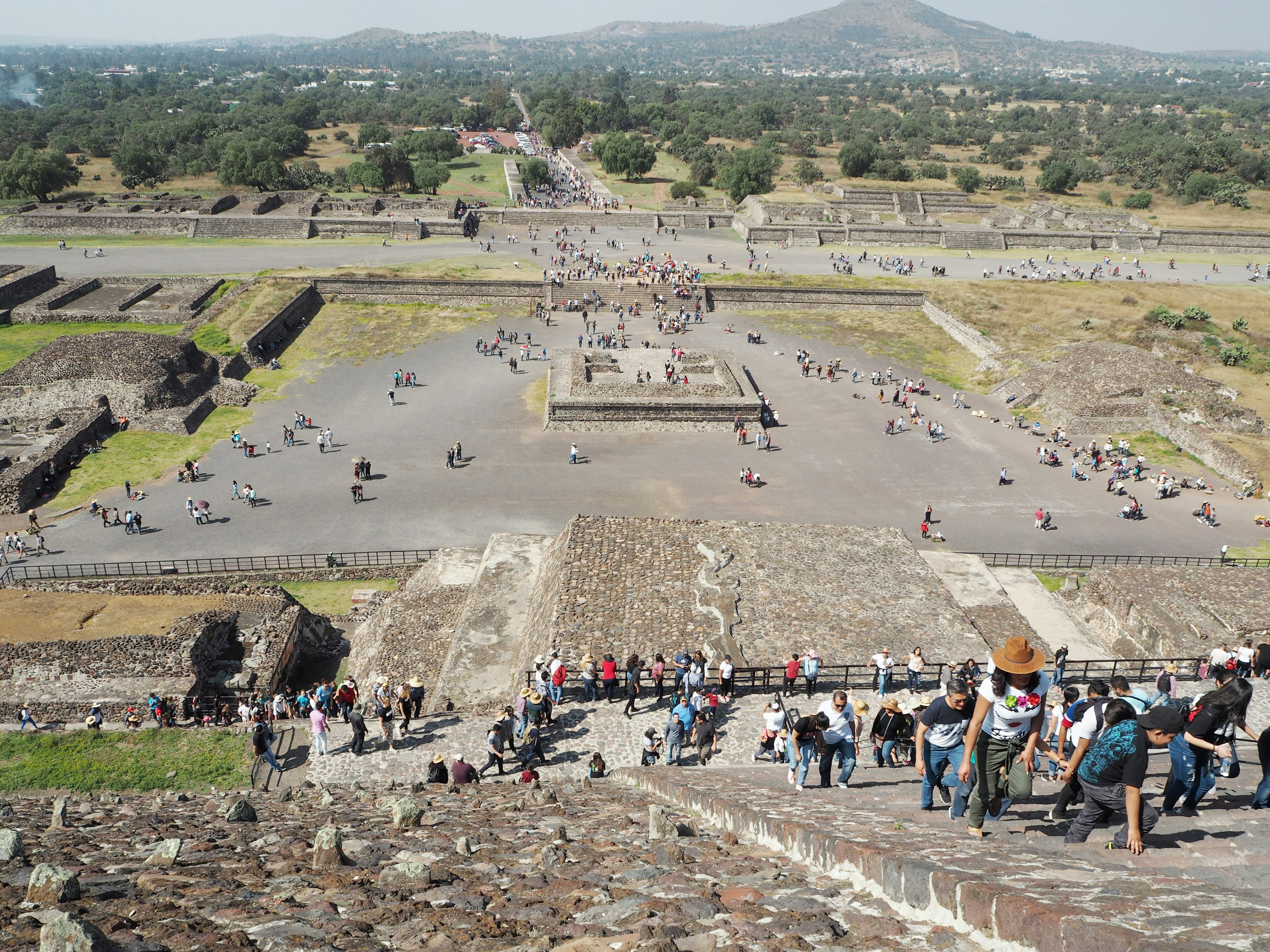 Pemandangan Piramida Matahari di Teotihuacan dengan pengunjung yang menjelajahi situs