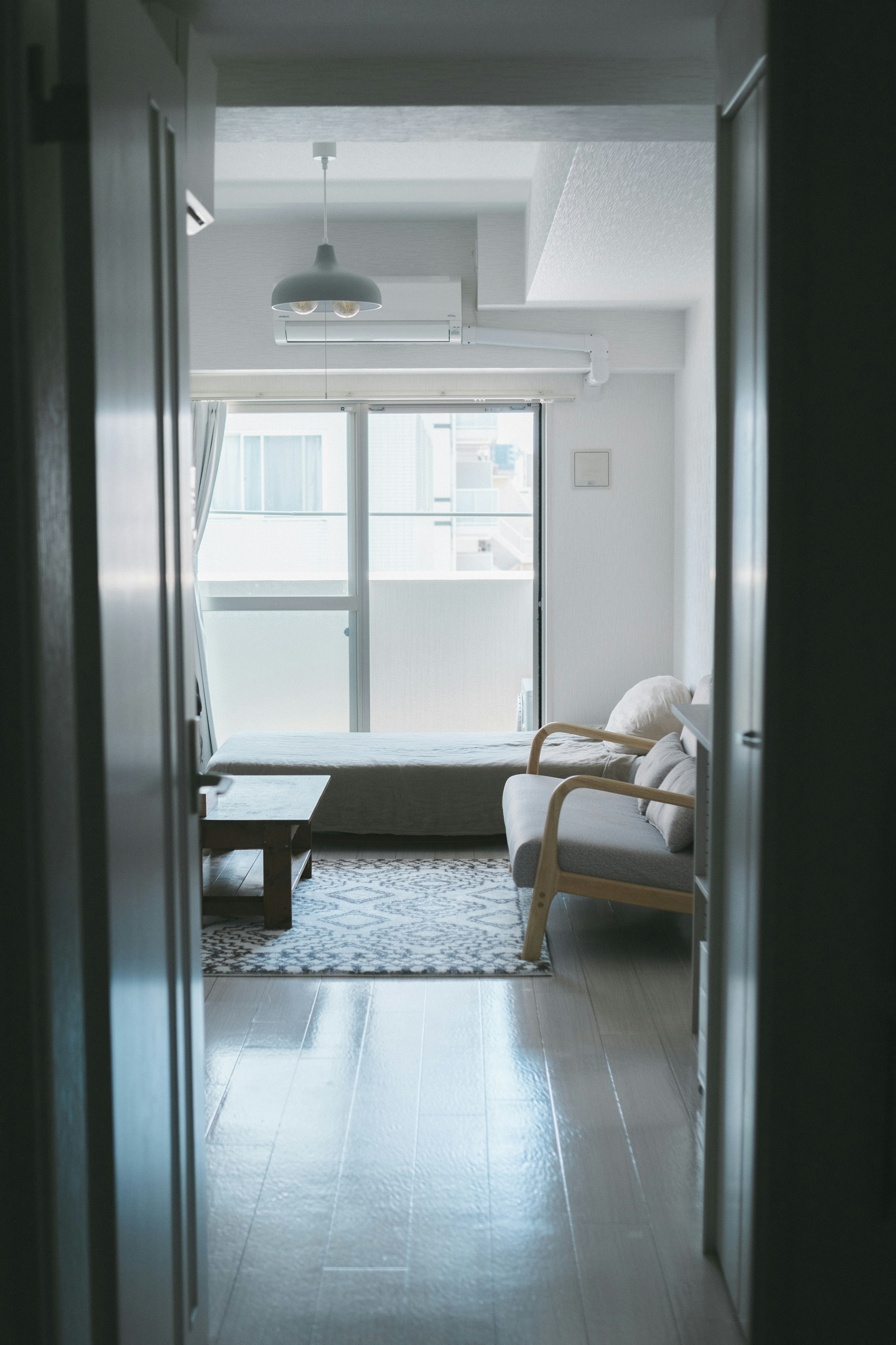 Blick auf ein einfaches Wohnzimmer mit weißen Wänden und einem Fenster