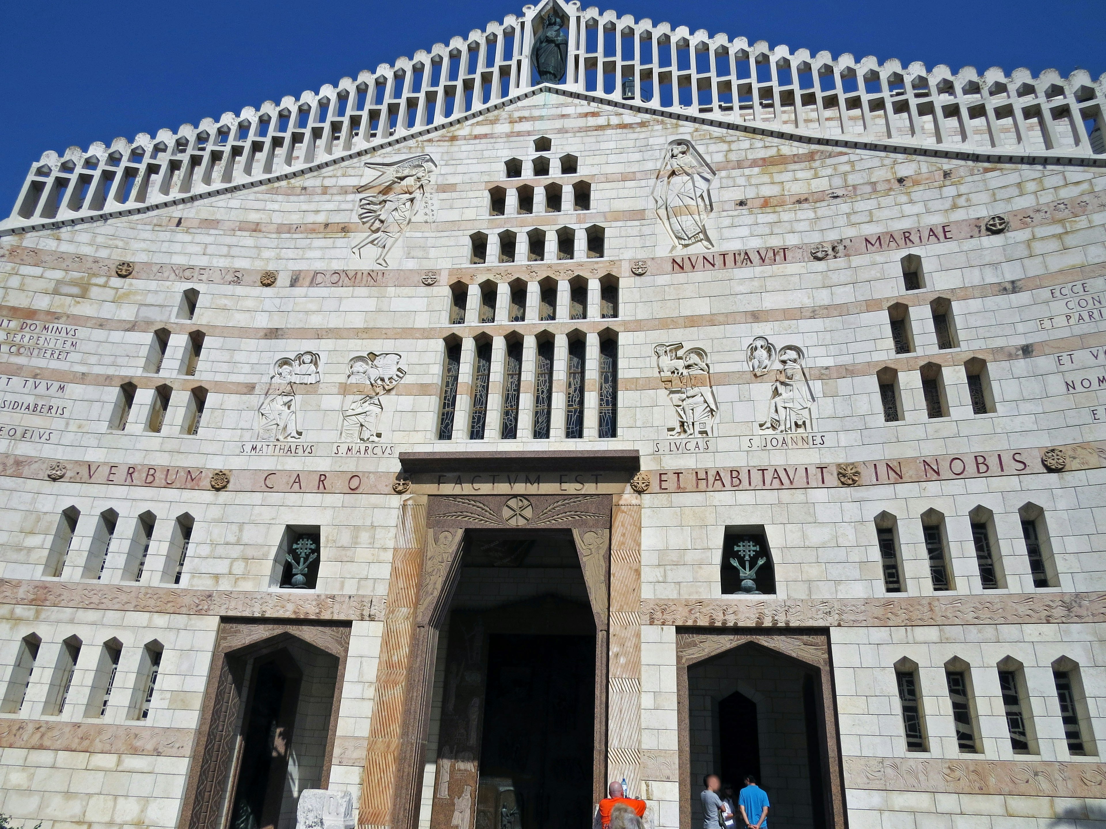 Façade d'un bâtiment marocain avec un design architectural unique en pierre blanche sous un ciel bleu