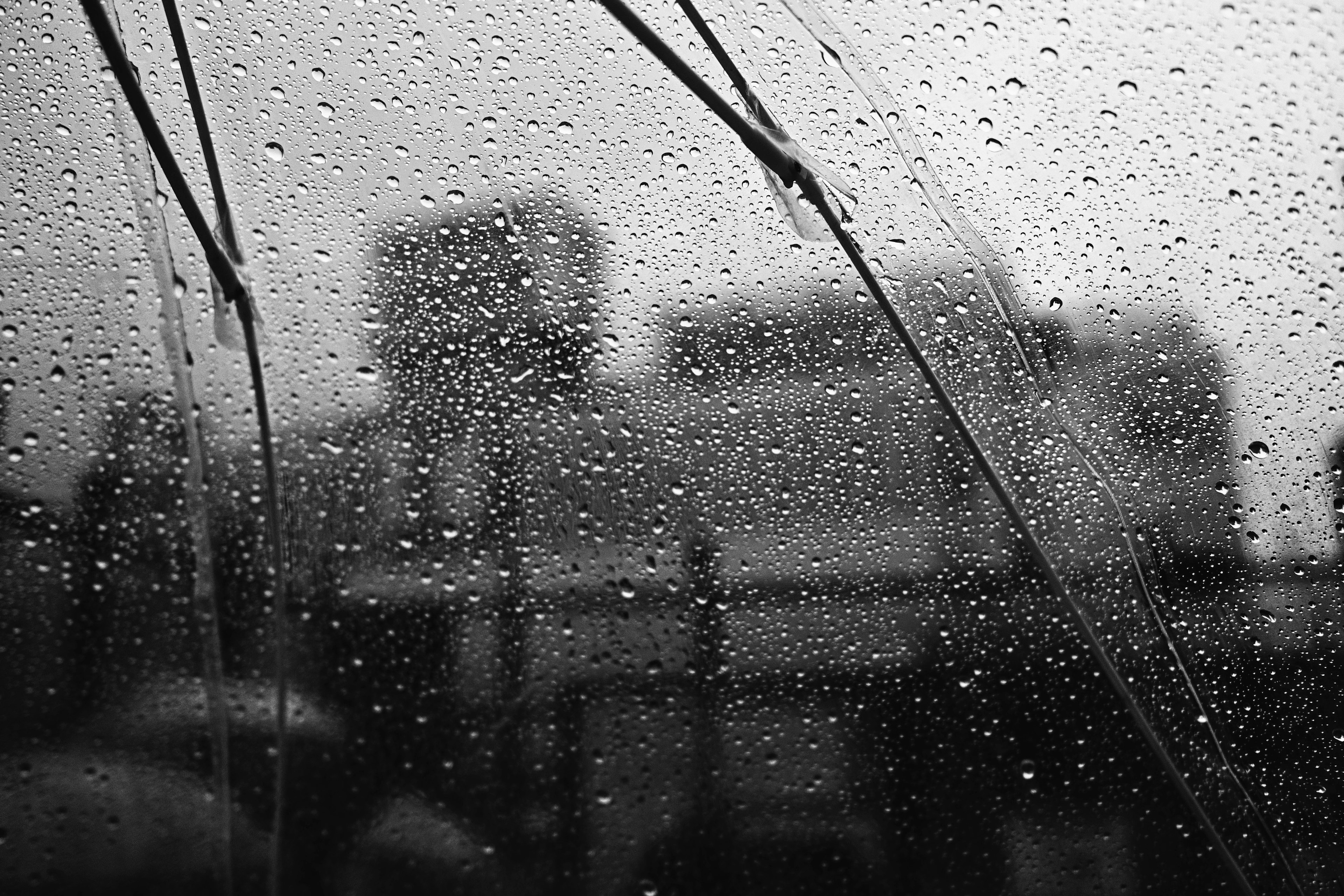 Paisaje urbano borroso visto a través de una ventana salpicada de lluvia