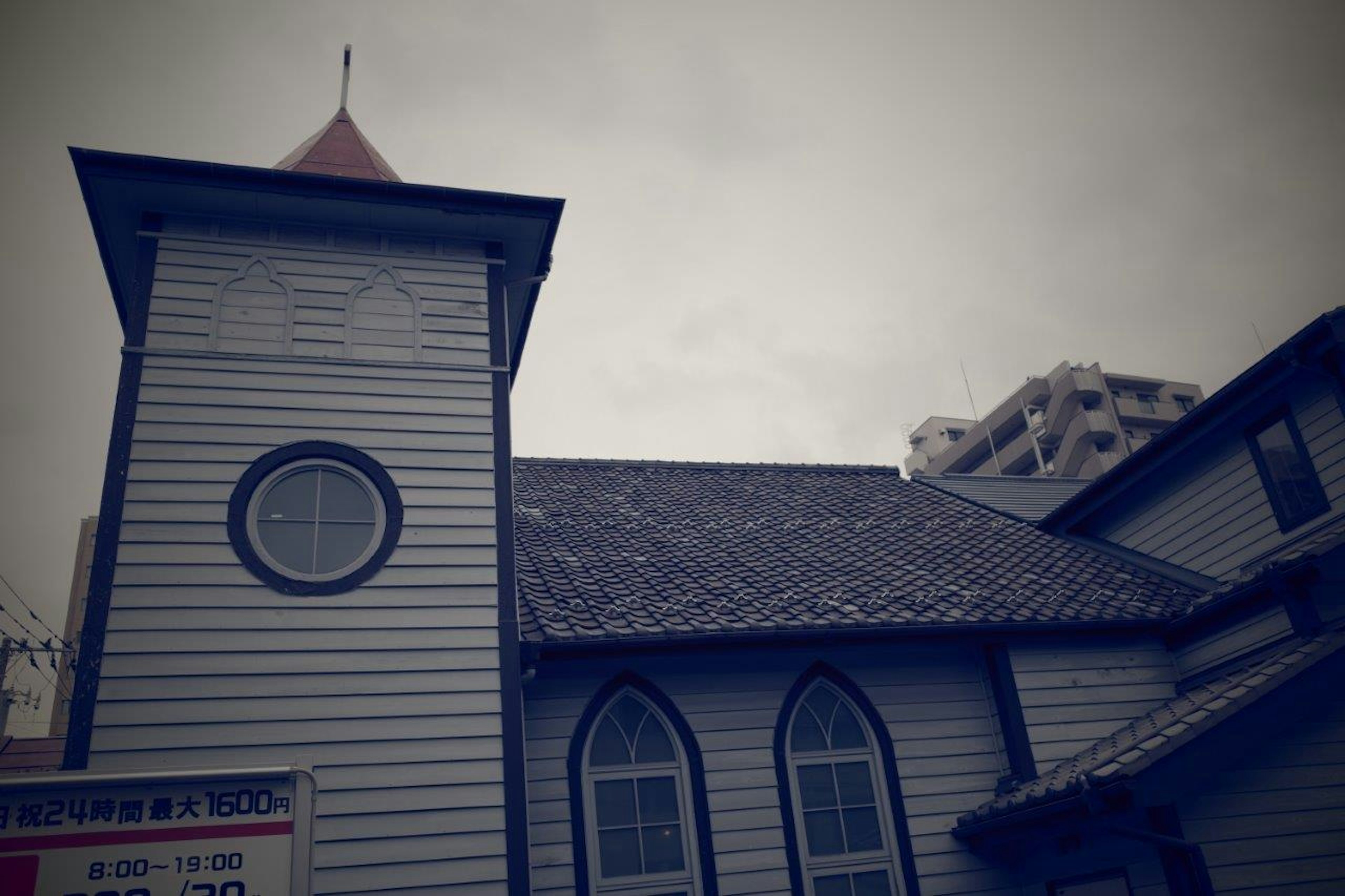 Bagian dari bangunan gereja kayu putih di bawah langit abu-abu