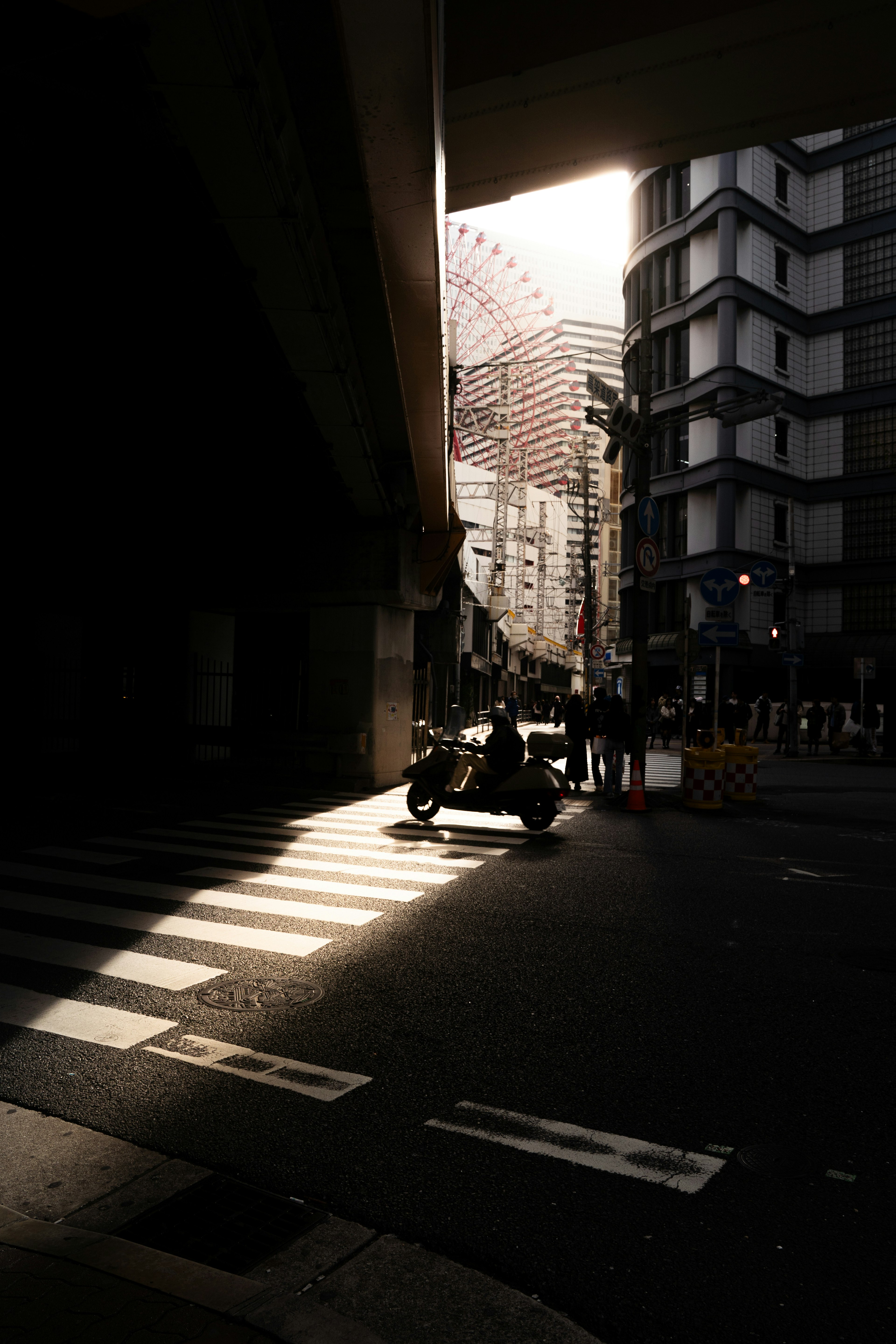 都市の交差点でのバイクと建物の明暗のコントラスト