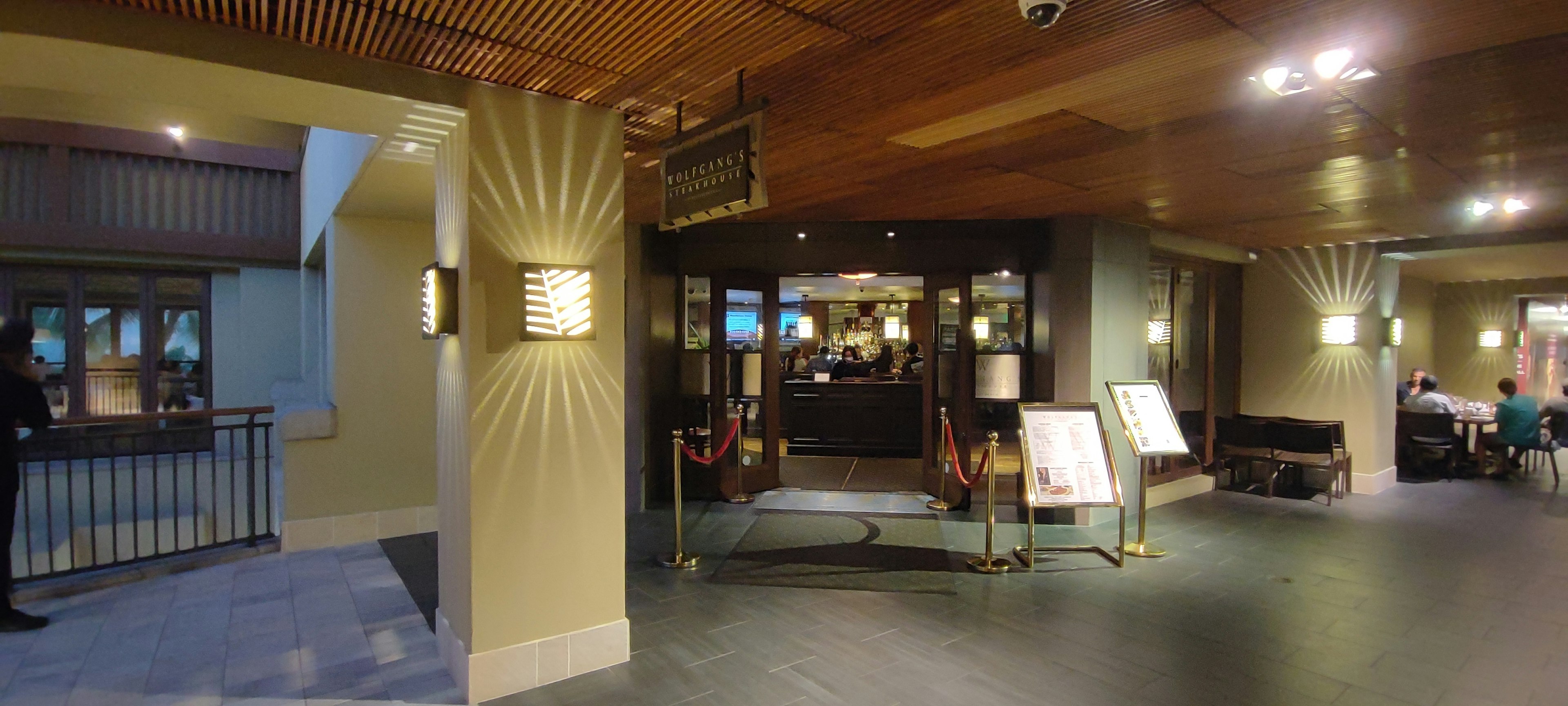 Modern lobby interior with wooden ceiling and soft lighting featuring a reception desk