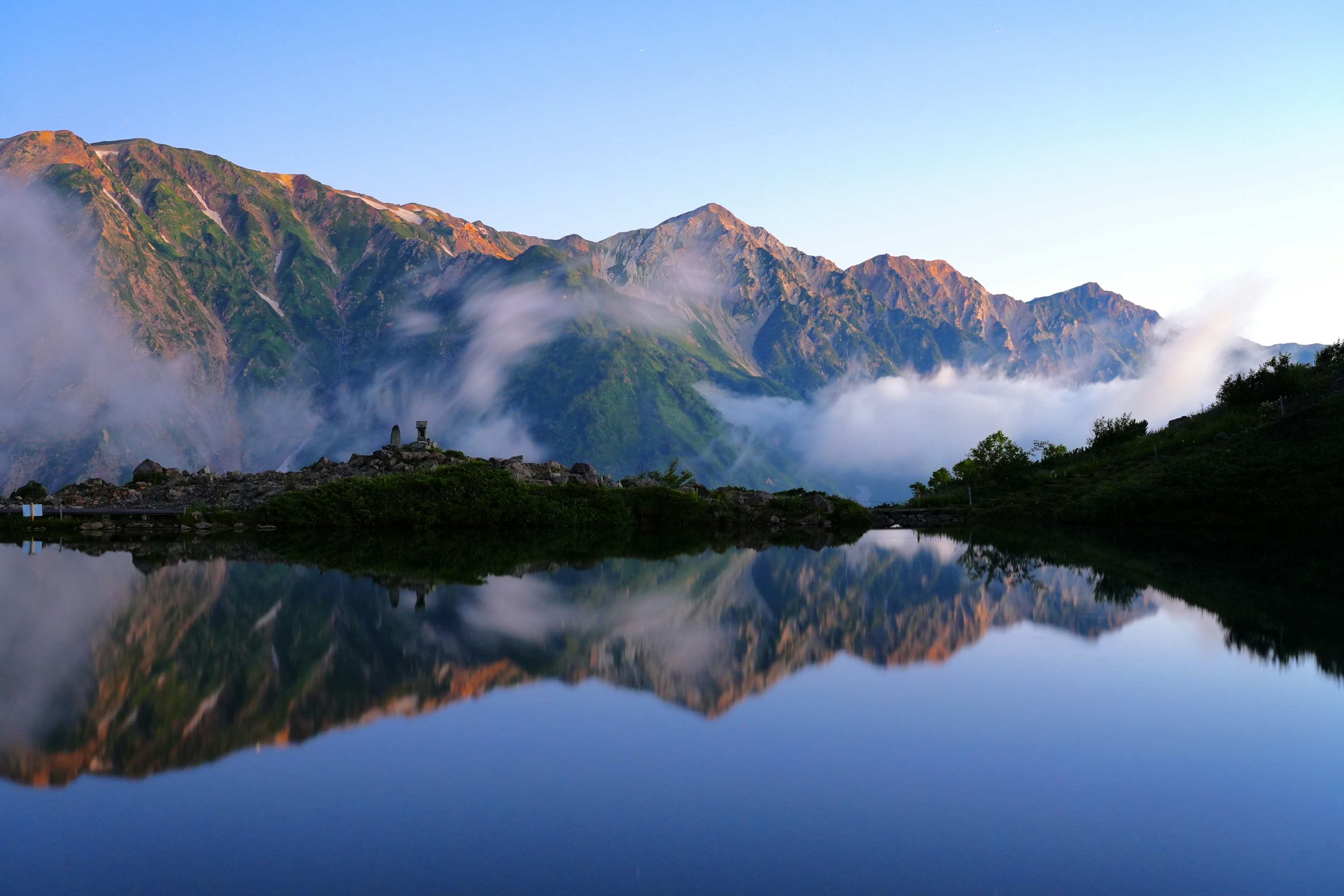 Vista escénica de montañas reflejándose en un lago tranquilo