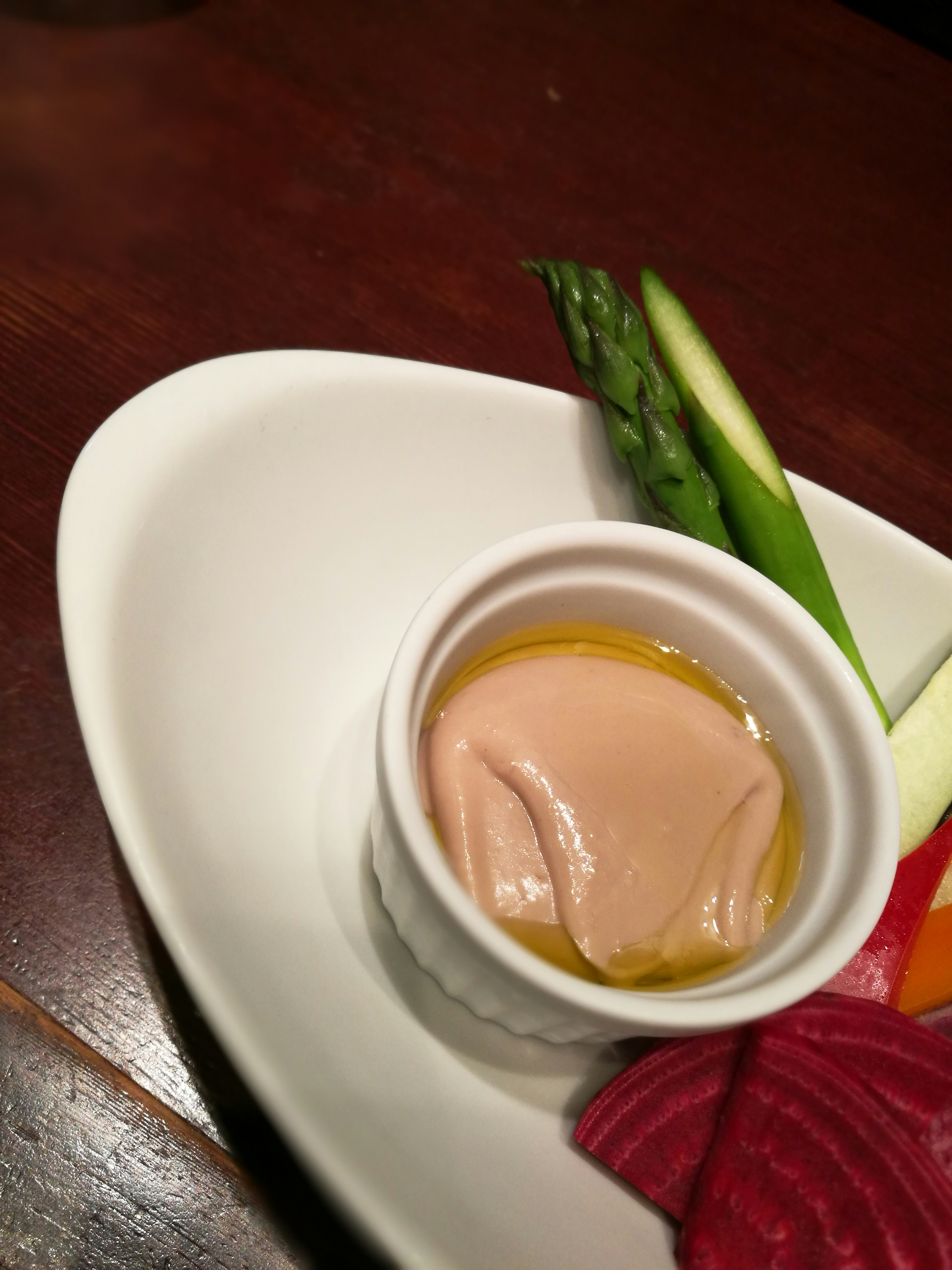 Plate featuring assorted vegetables and a small cup of sauce