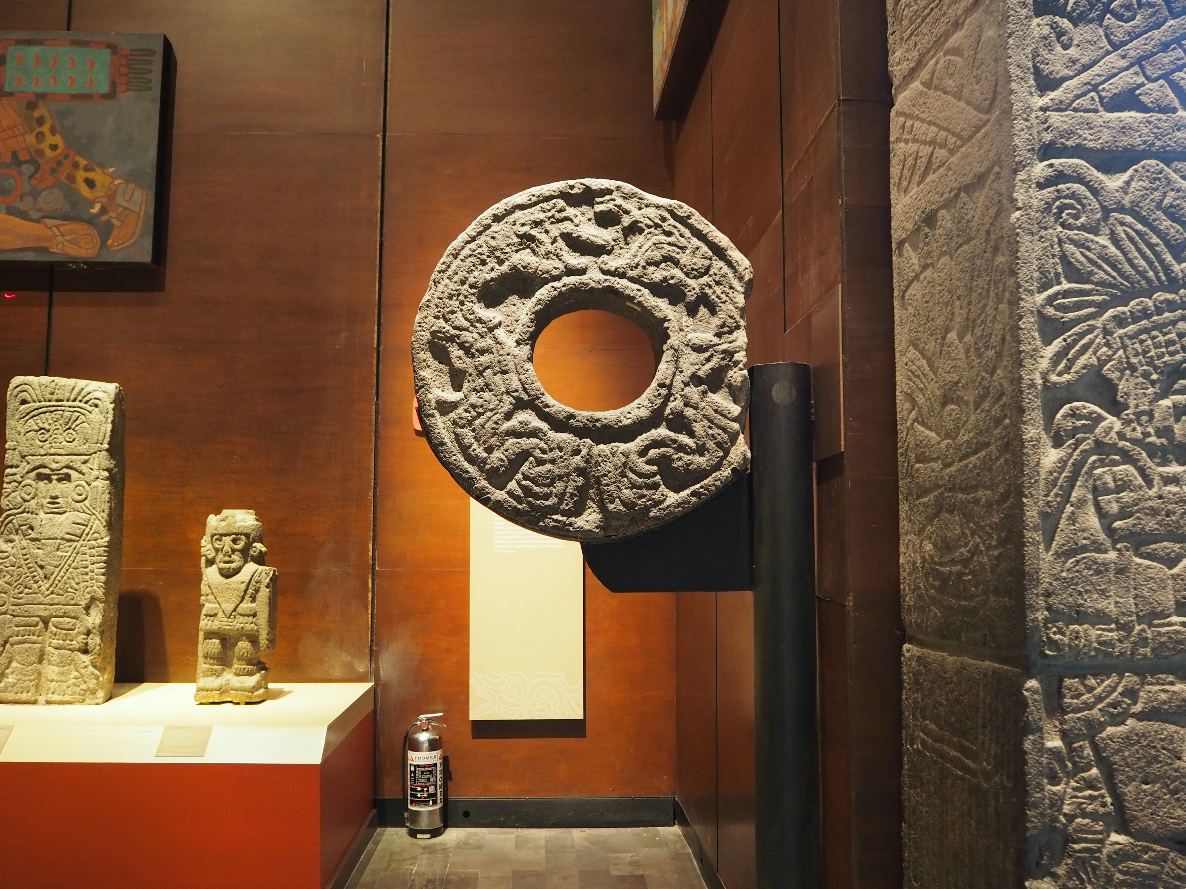 Objeto circular de piedra antigua expuesto en el interior de un museo