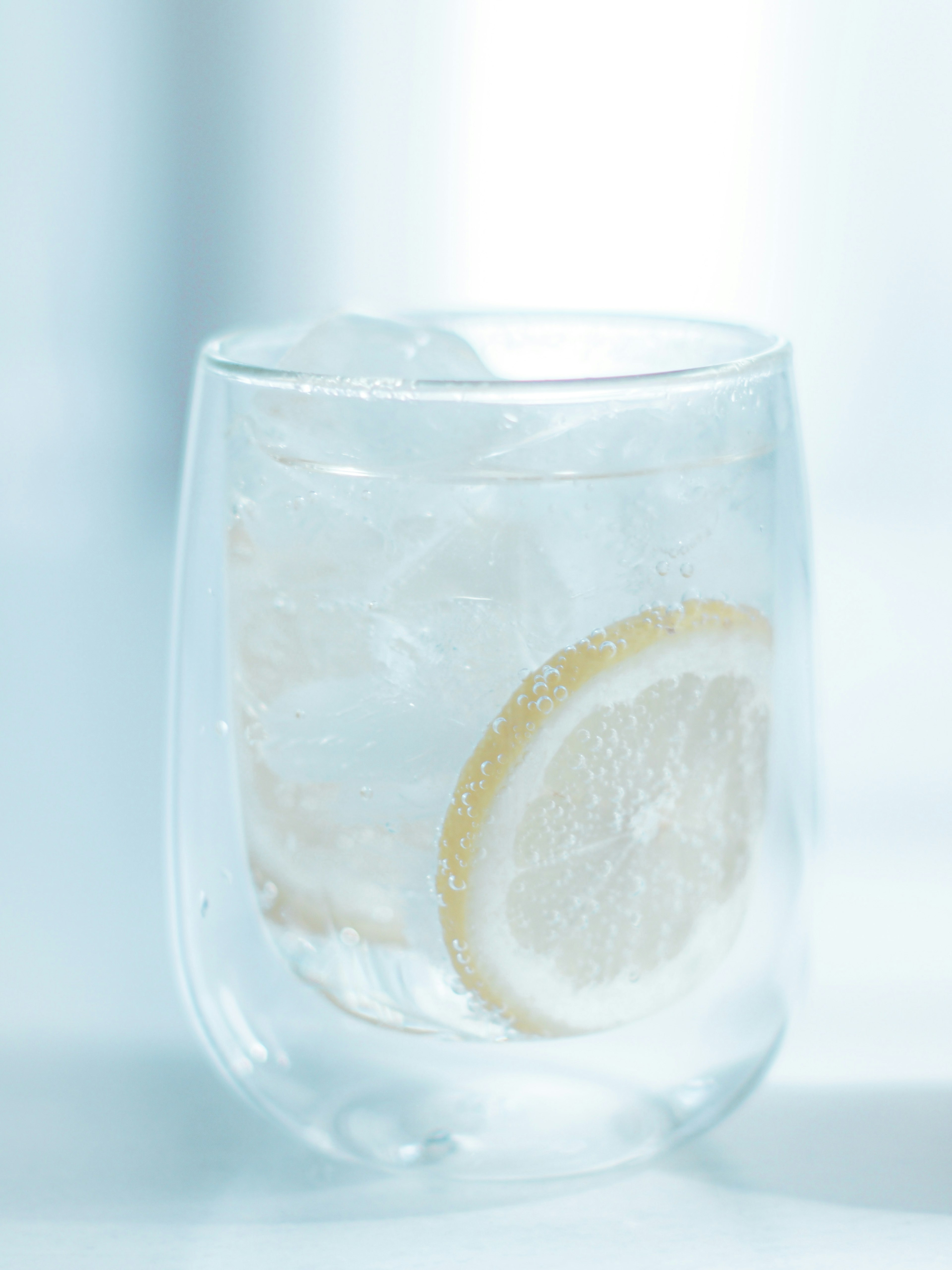 Verre transparent d'eau avec des glaçons et une tranche de citron