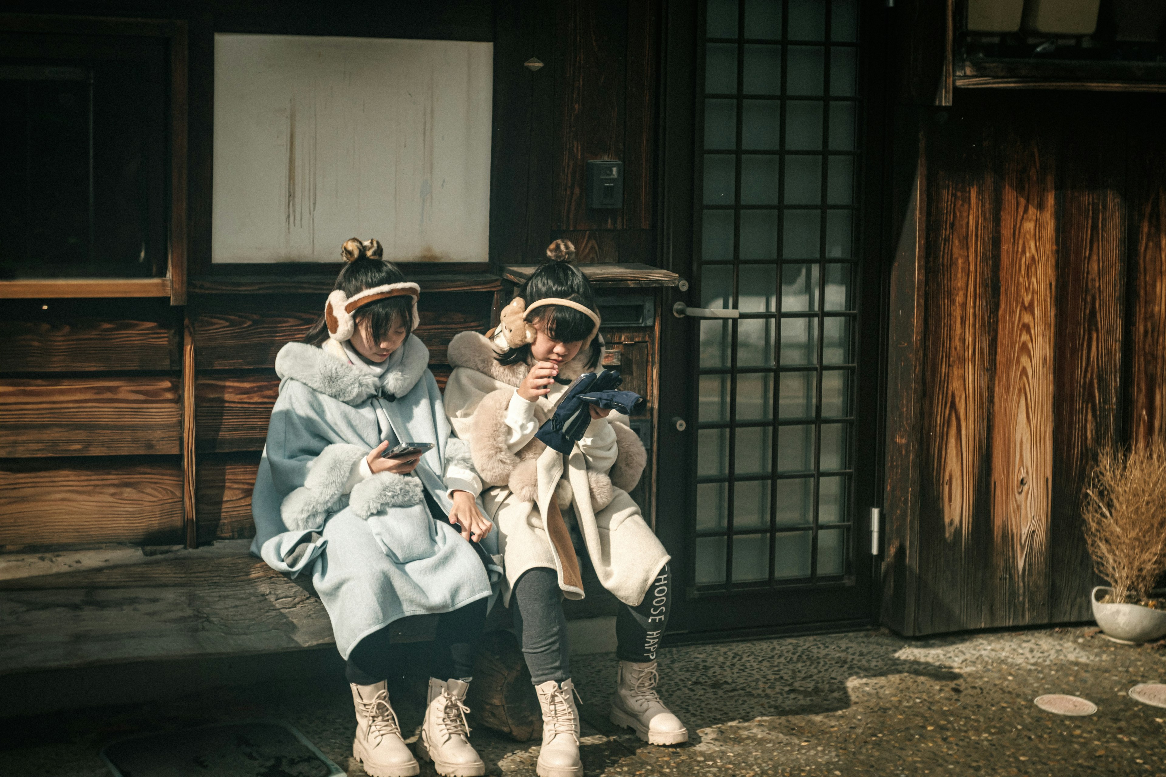 Deux enfants assis devant une maison japonaise traditionnelle