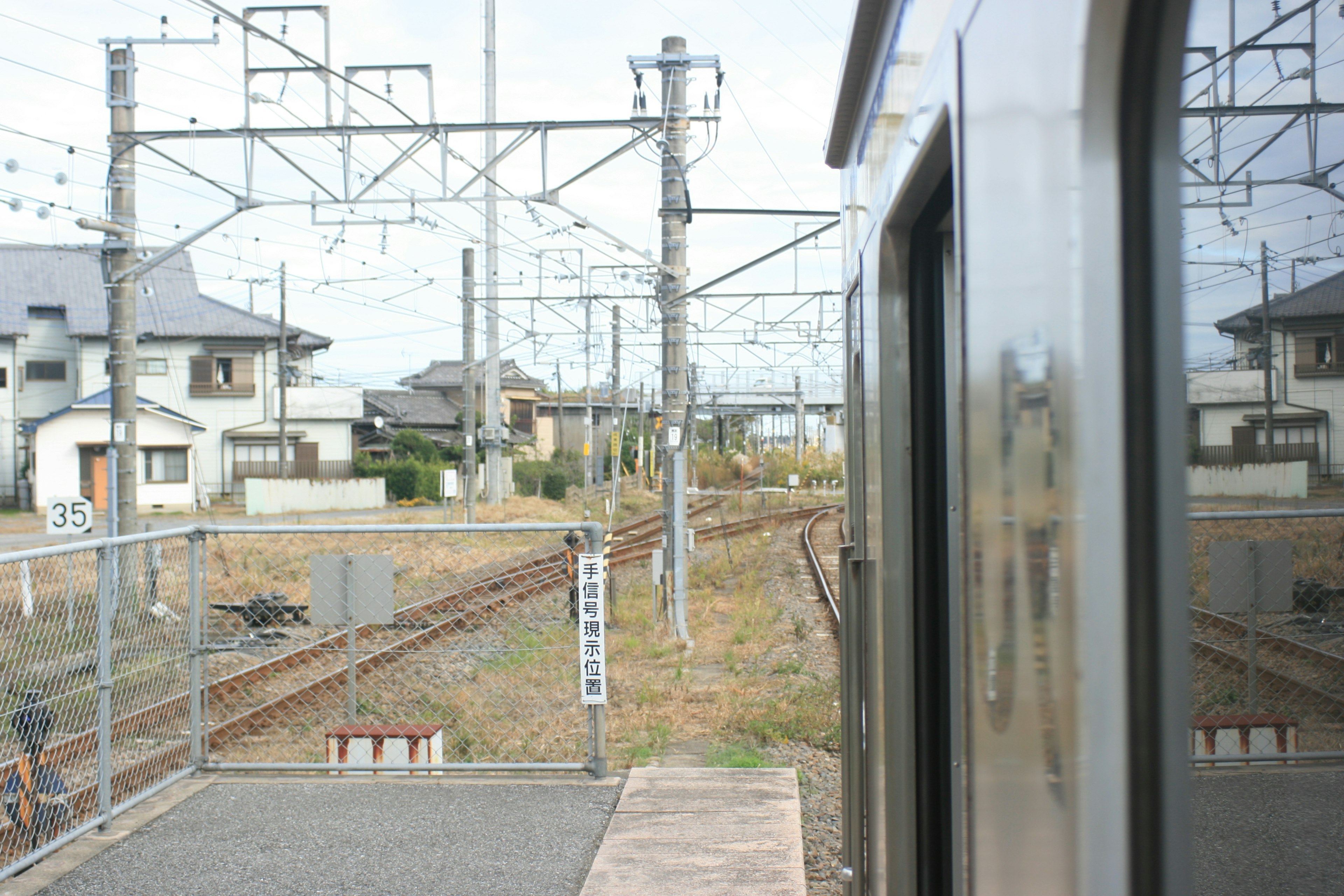 電車の窓から見える郊外の風景と線路