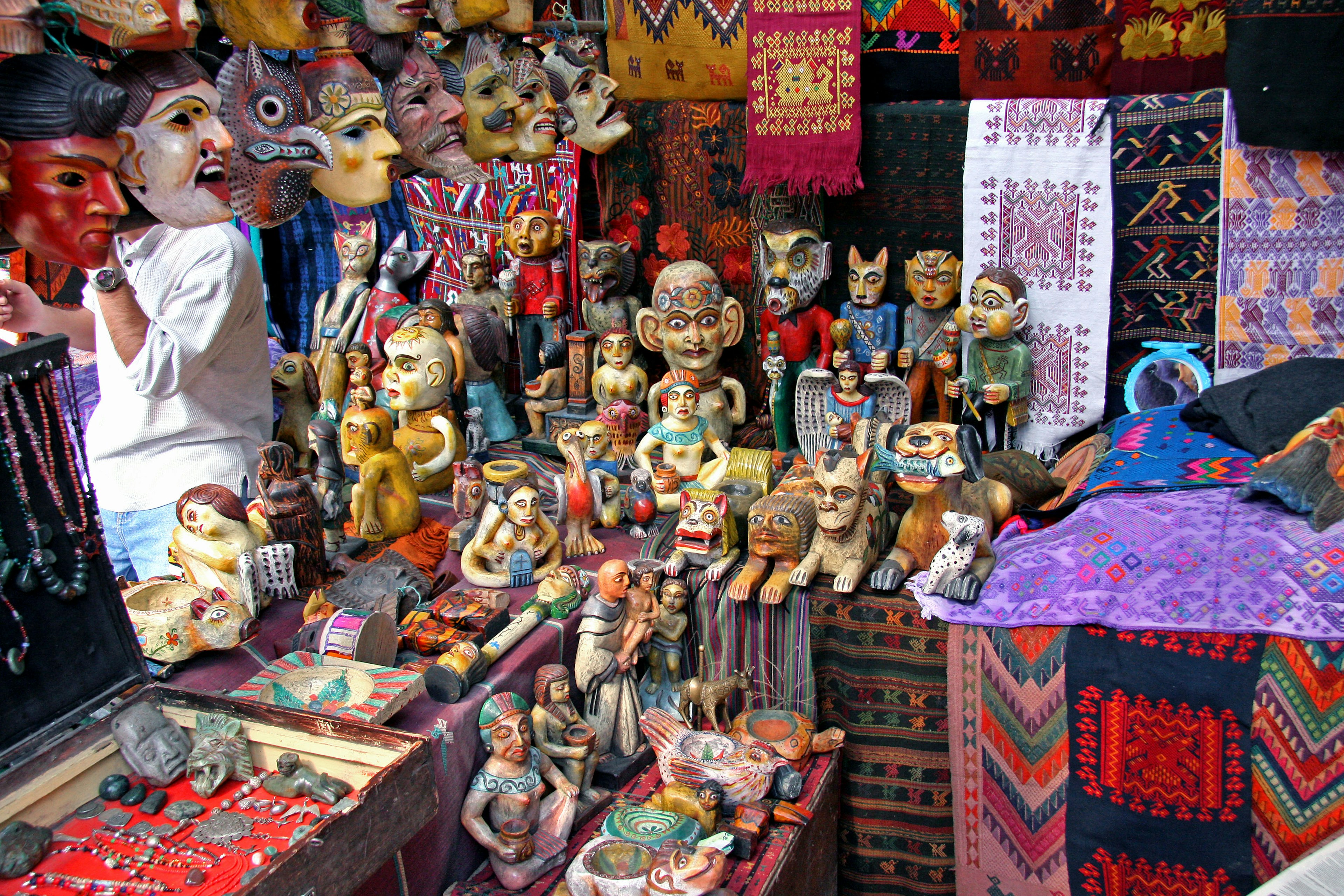 Colorful handmade sculptures and figurines displayed in a market setting