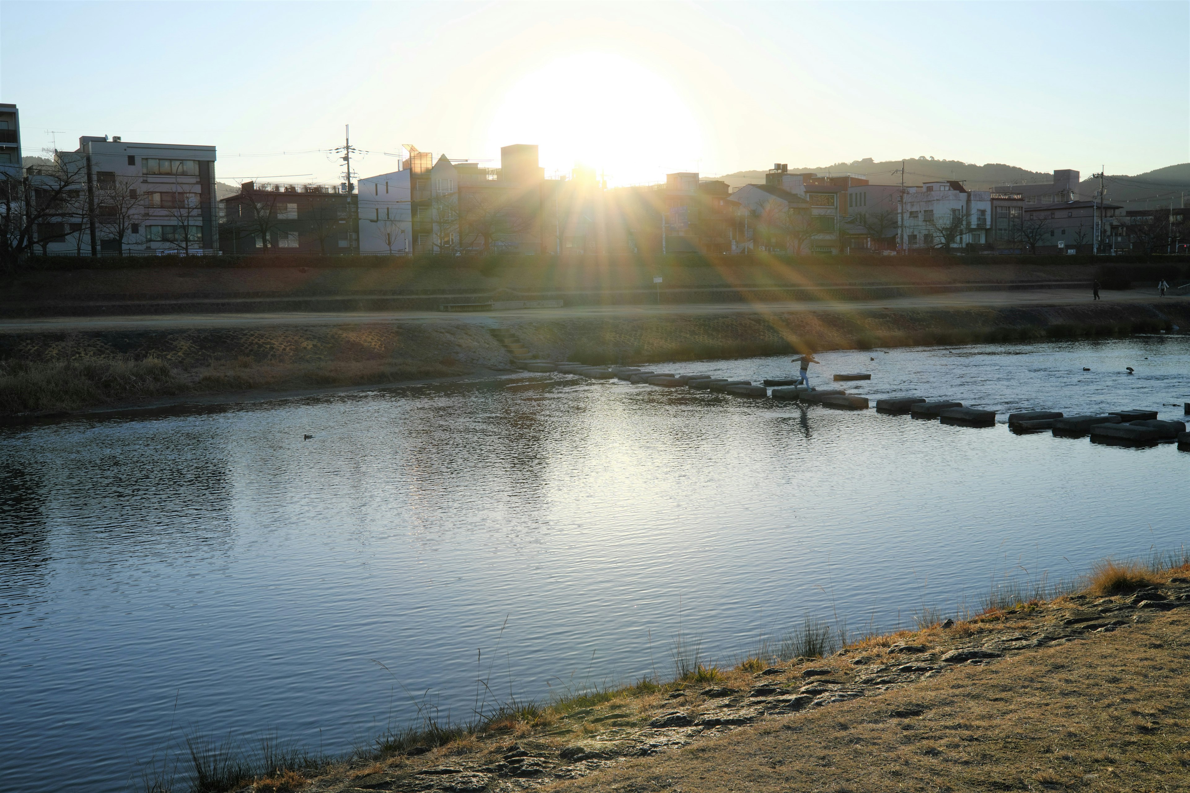 川の上に輝く夕日と静かな水面の風景