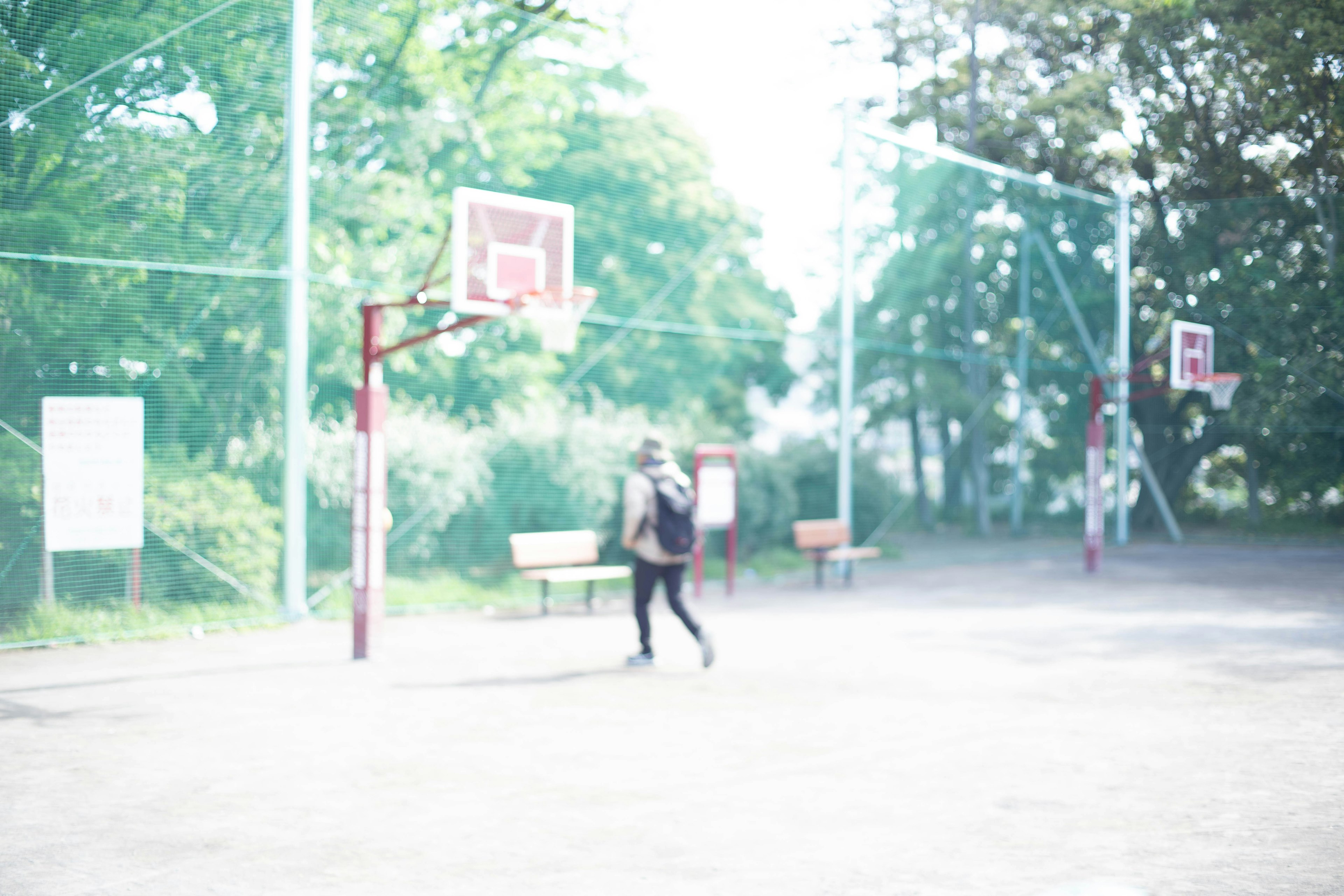 Person on a basketball court with hoops and benches