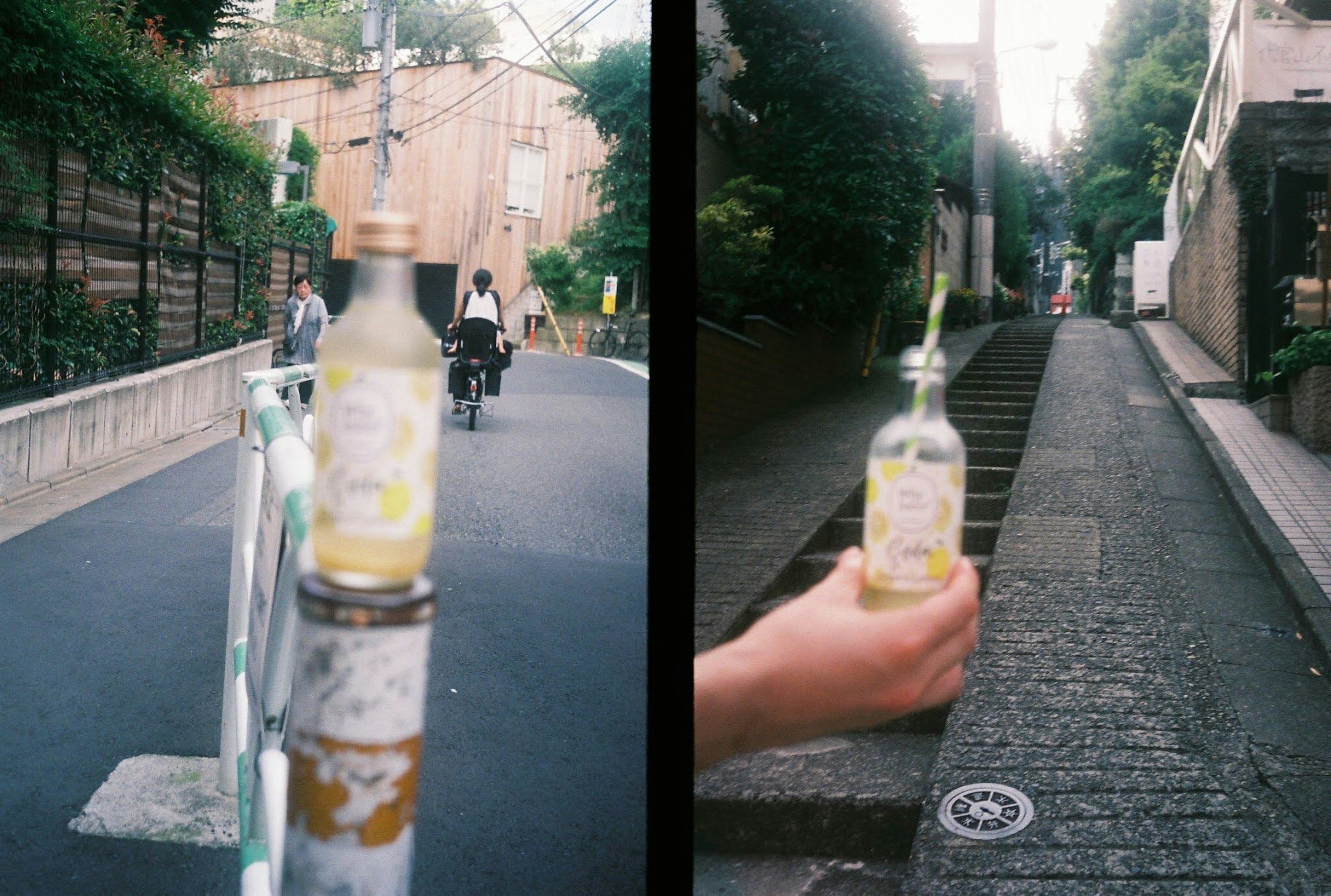 A beverage bottle on a street barrier and held by a person on a narrow path