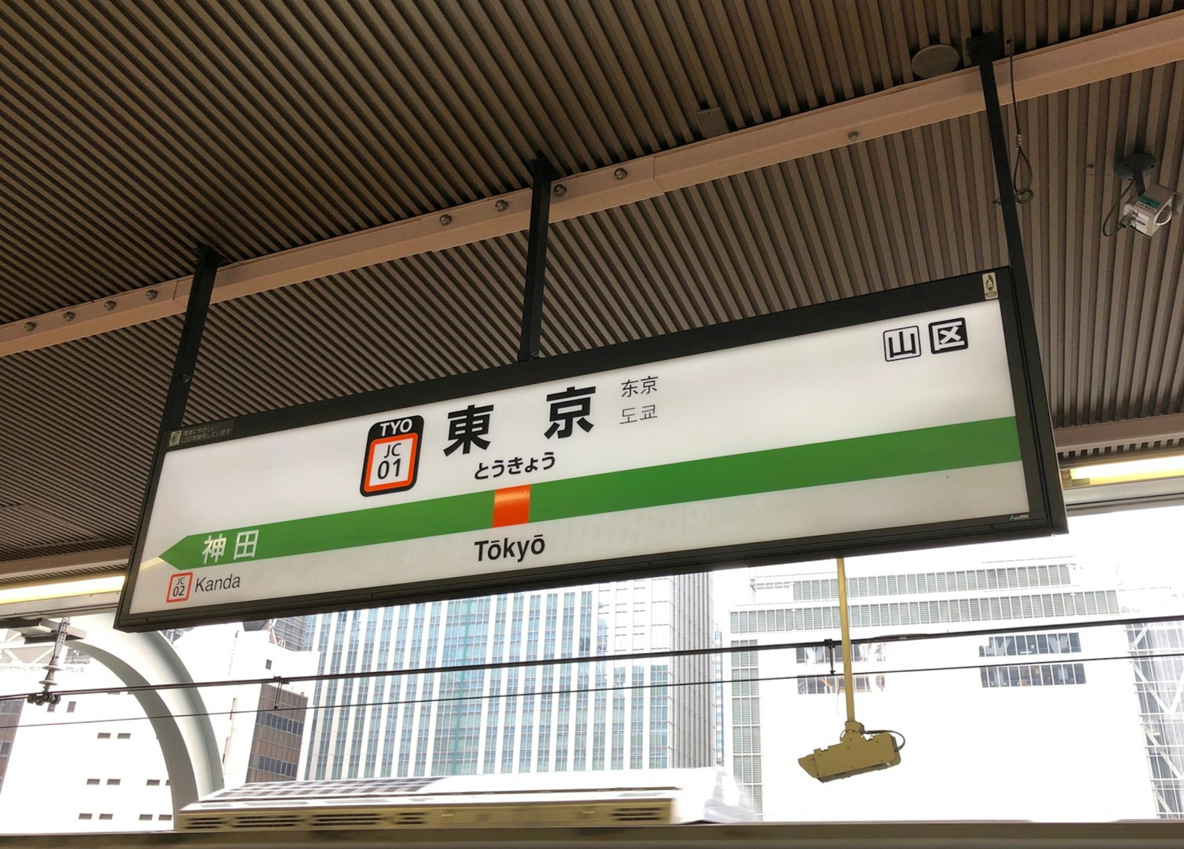 Tokyo station sign with a green line feature