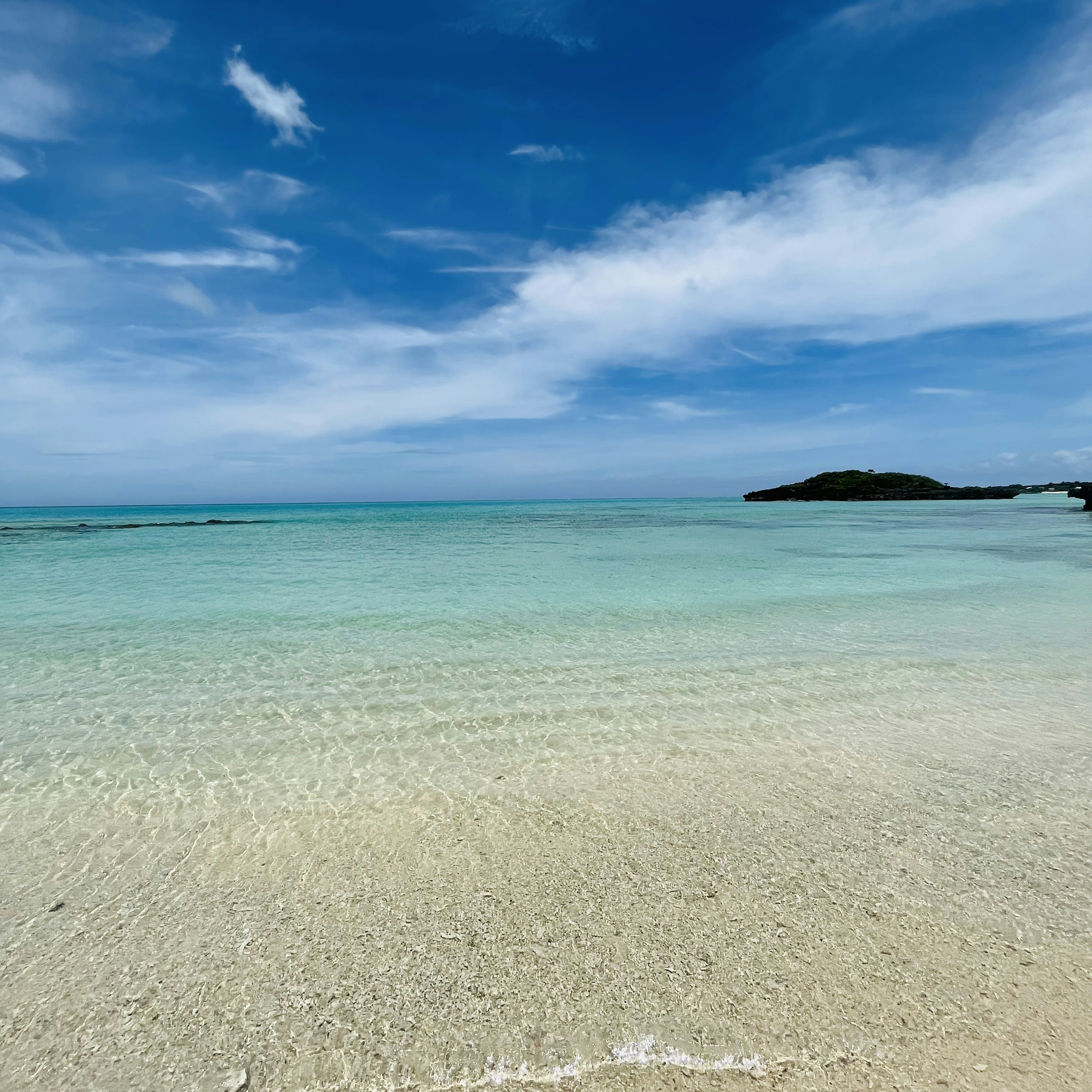 ชายหาดที่สวยงามมีทะเลสีฟ้าและชายหาดสีขาว