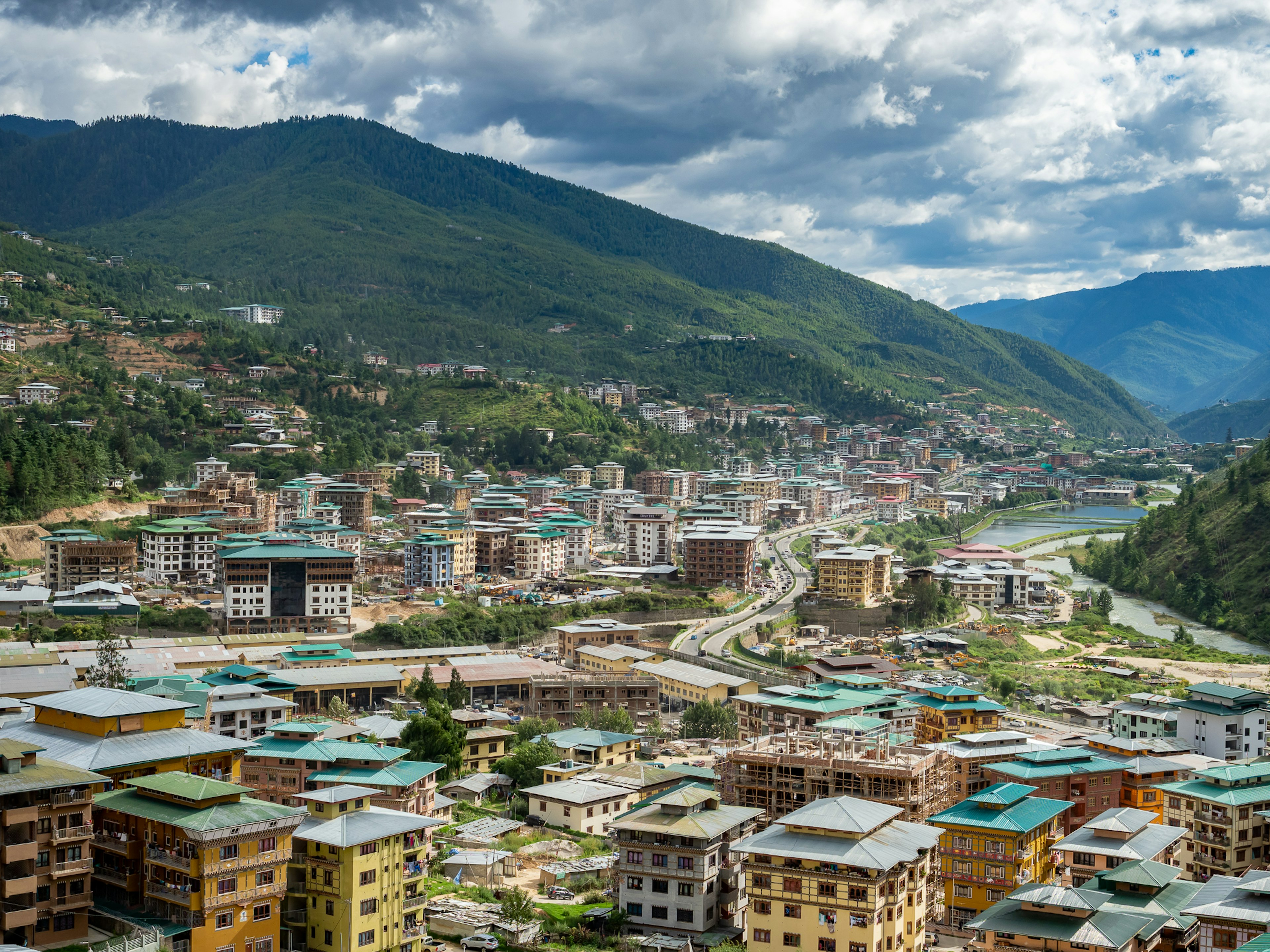 Pemandangan indah kota Bhutan dikelilingi gunung yang indah menampilkan bangunan dan jalan