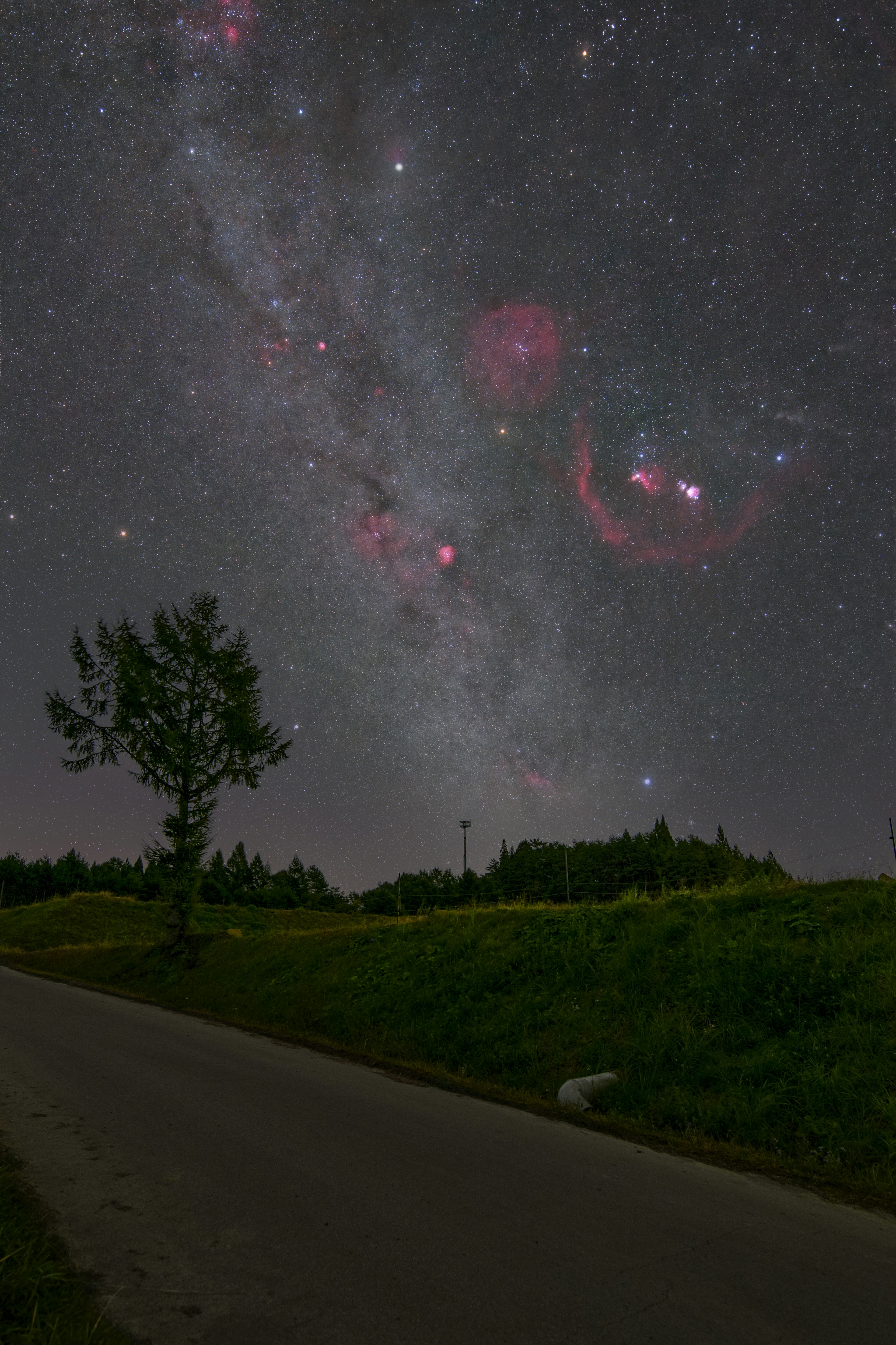 星空に広がる天の川と赤い星雲の美しい景色