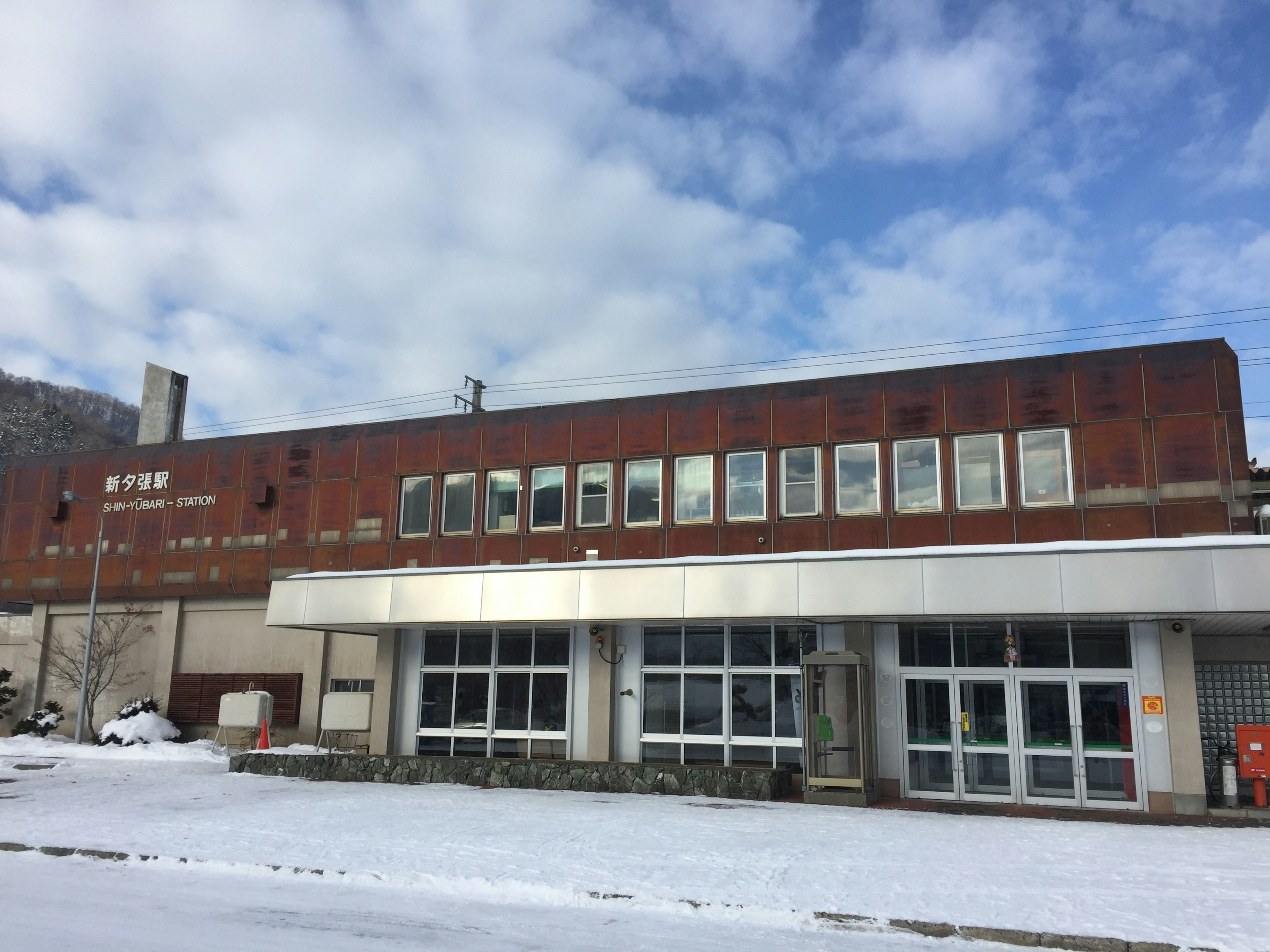 Old building covered in snow with a rusty exterior and large windows