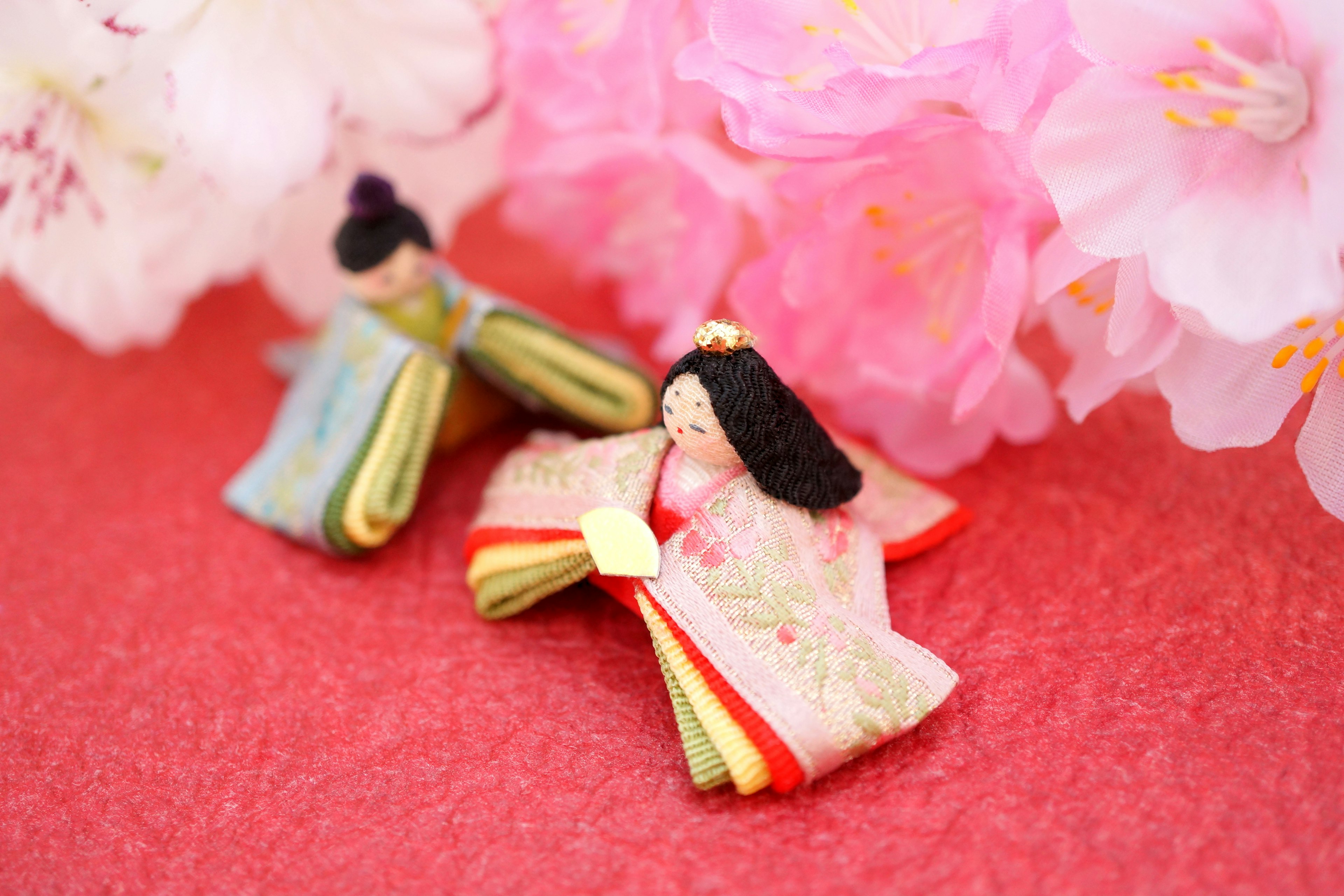 Traditional Japanese hina dolls with cherry blossoms in the background