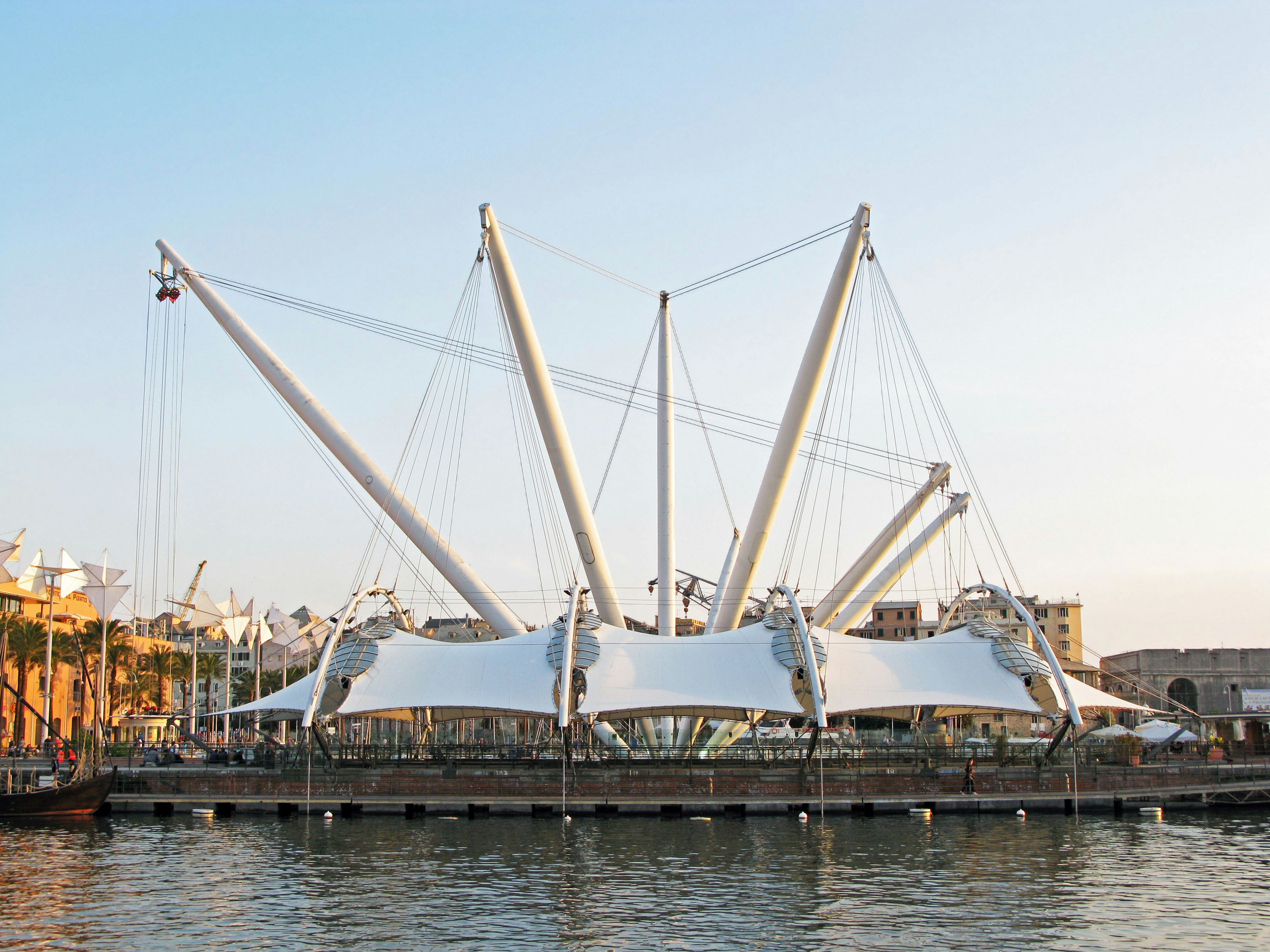 Modern architectural structure with white tent and steel framework by the sea