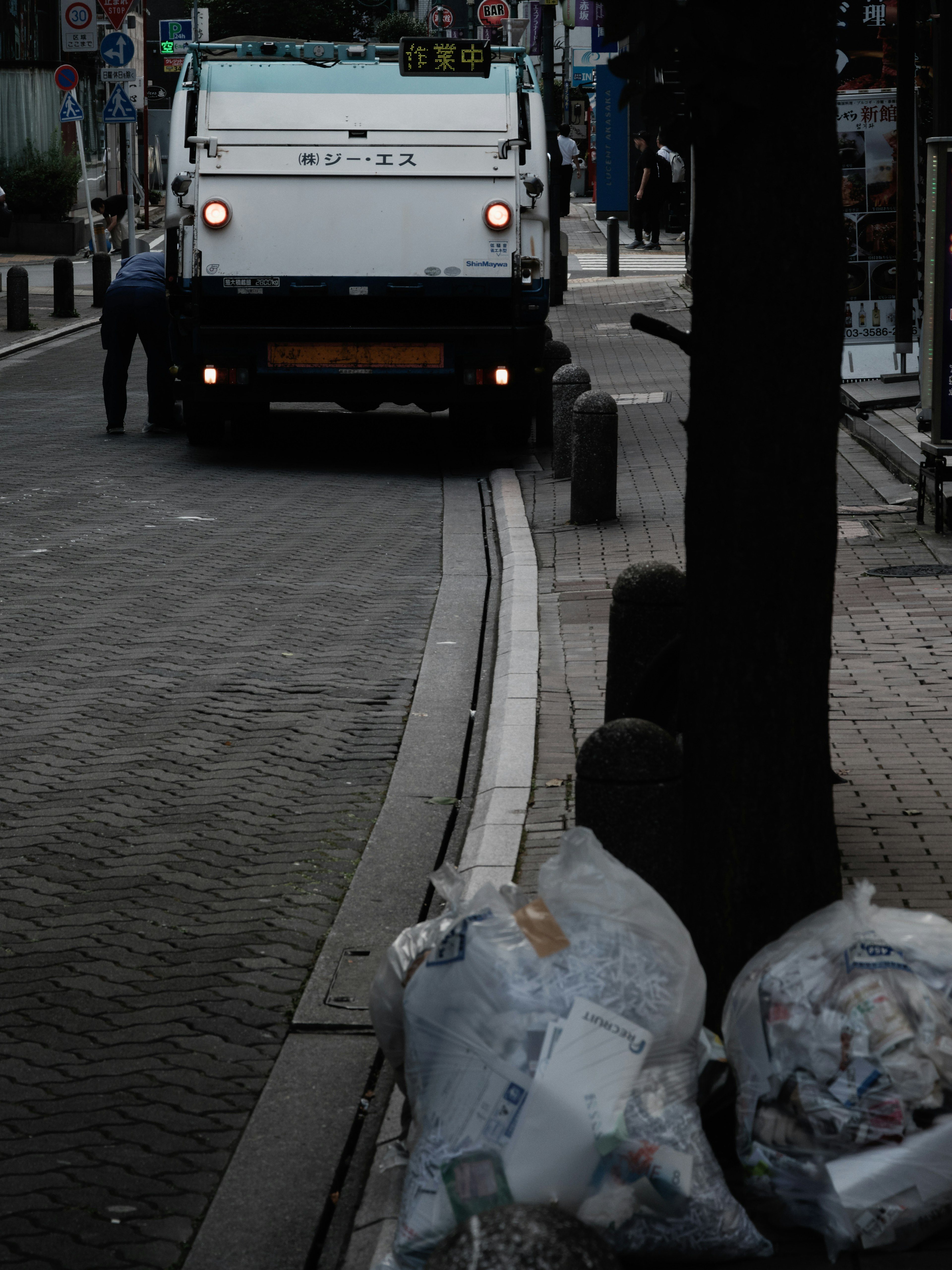 Scène d'un camion poubelle et de sacs à ordures dans la rue