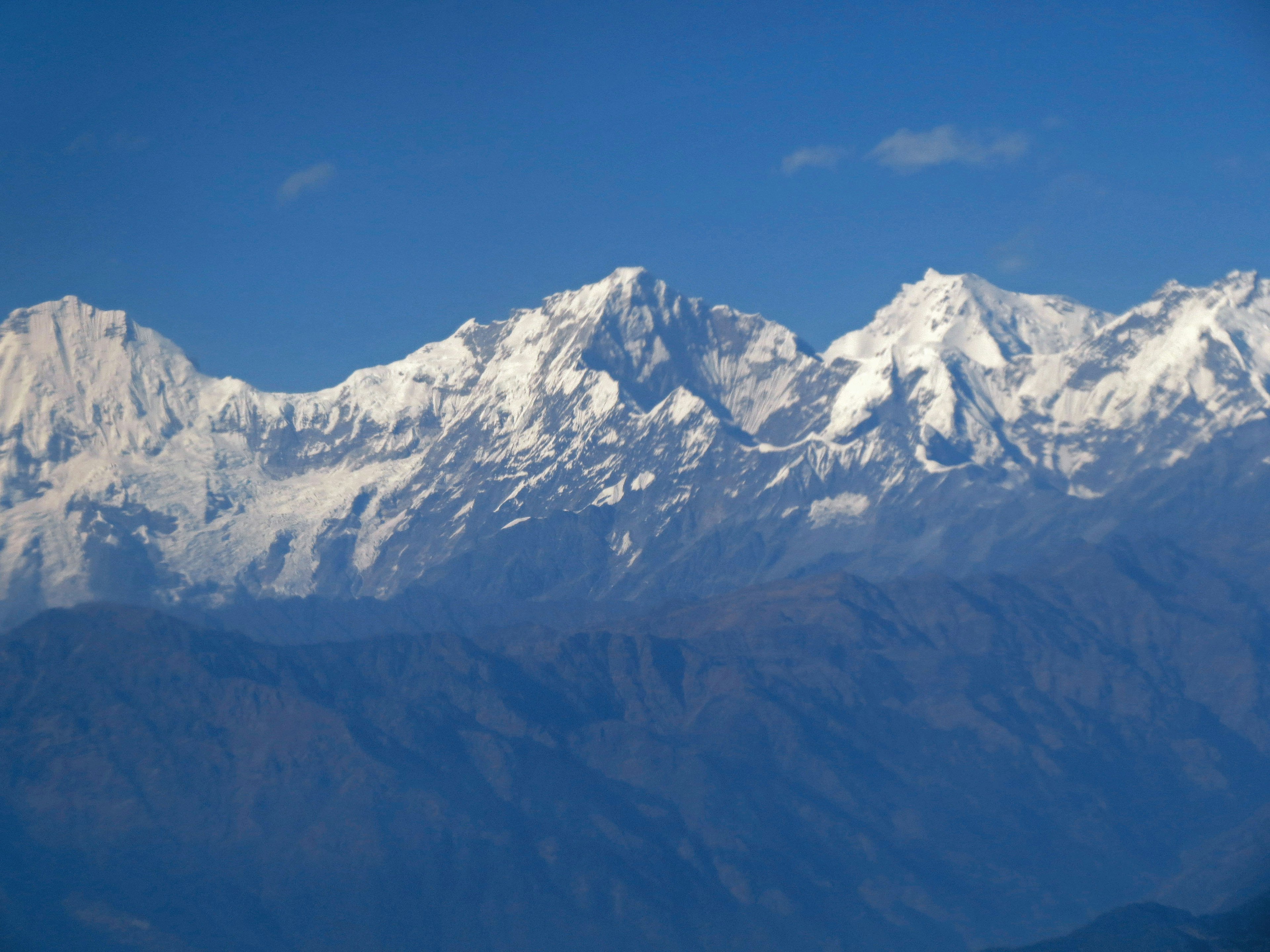 Gunung bersalju di bawah langit biru yang cerah