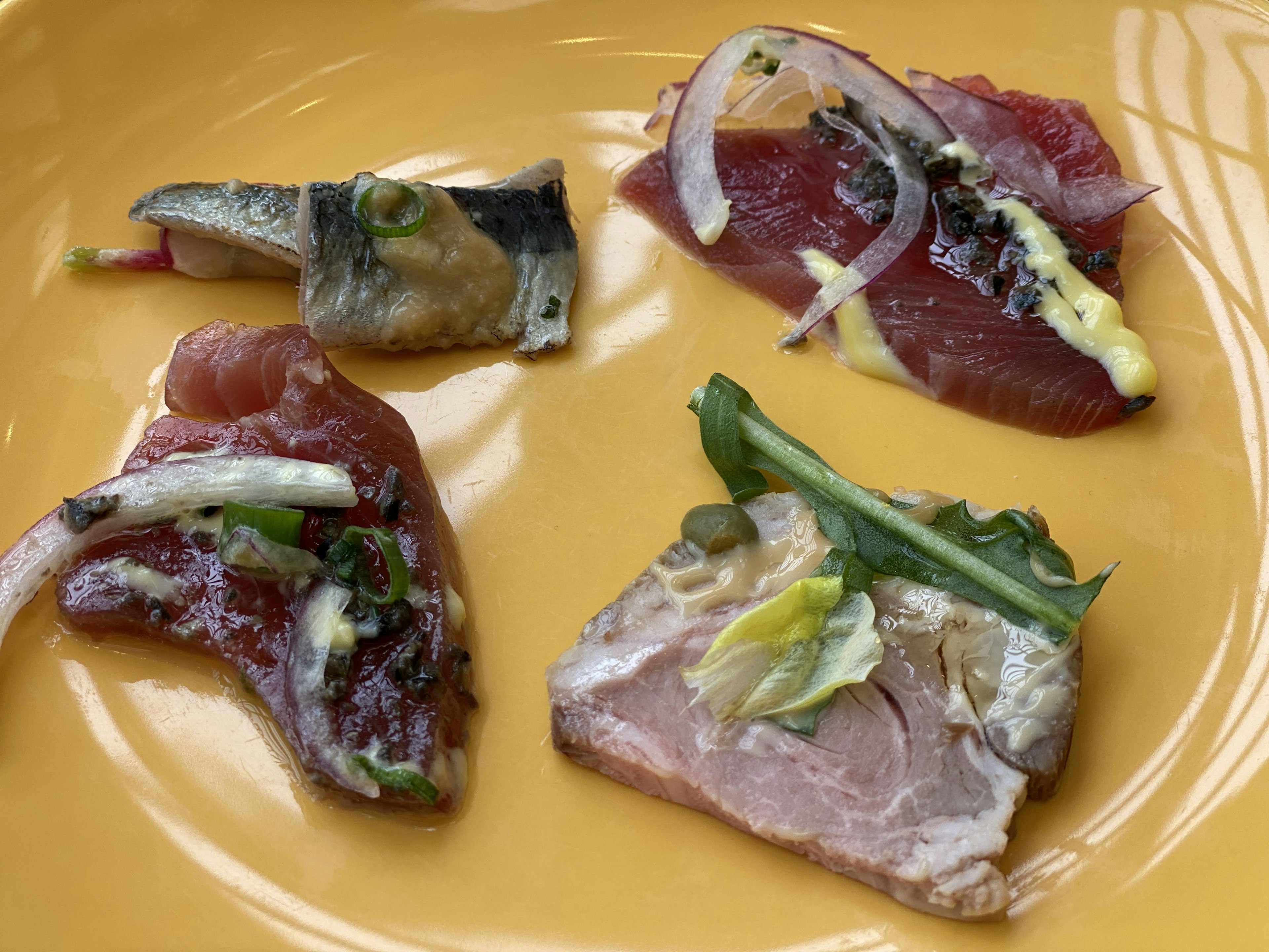 Piatto di sashimi con fette di pesce su un piatto giallo