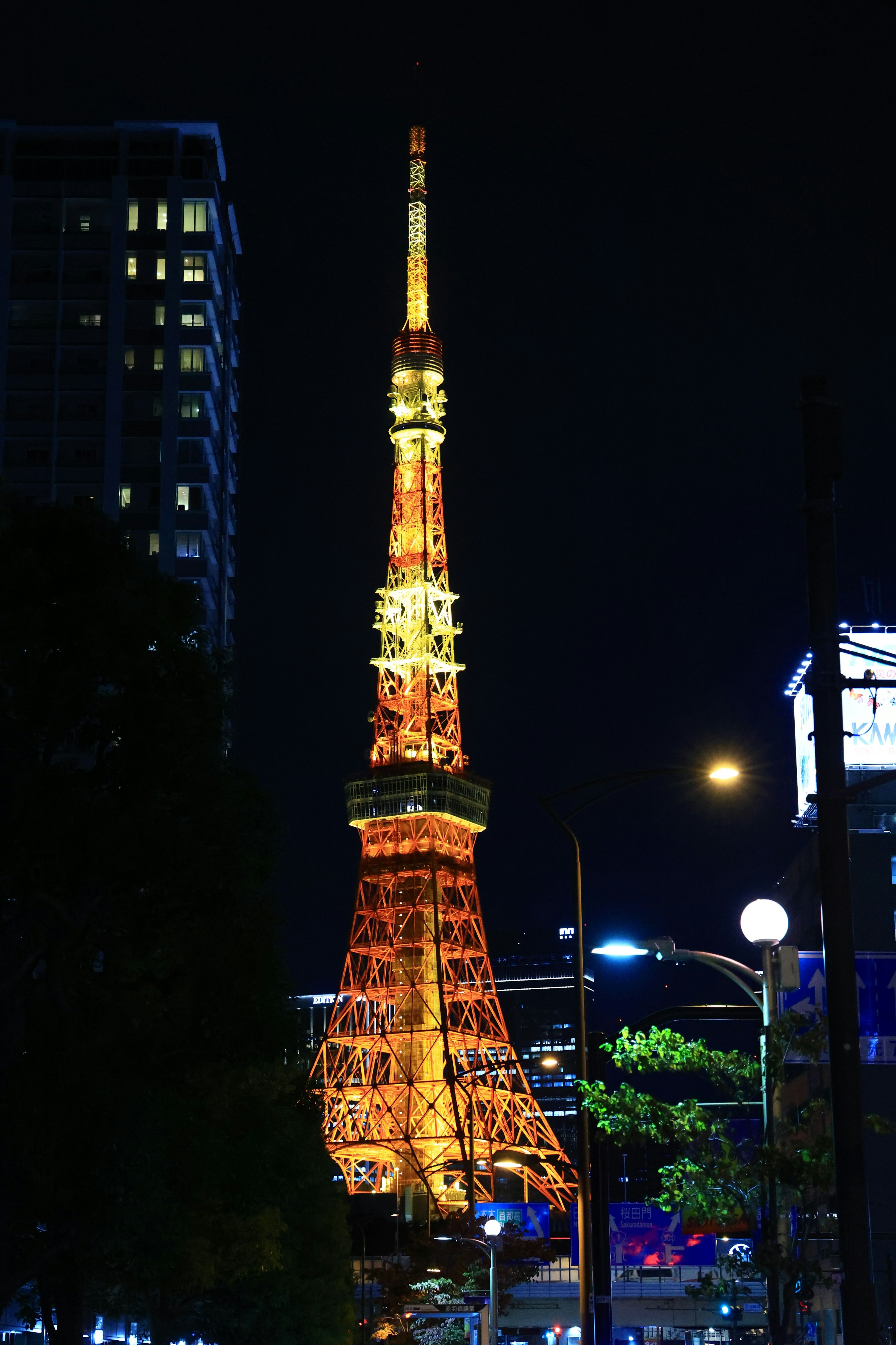 Tokyo Tower illuminated at night with surrounding buildings