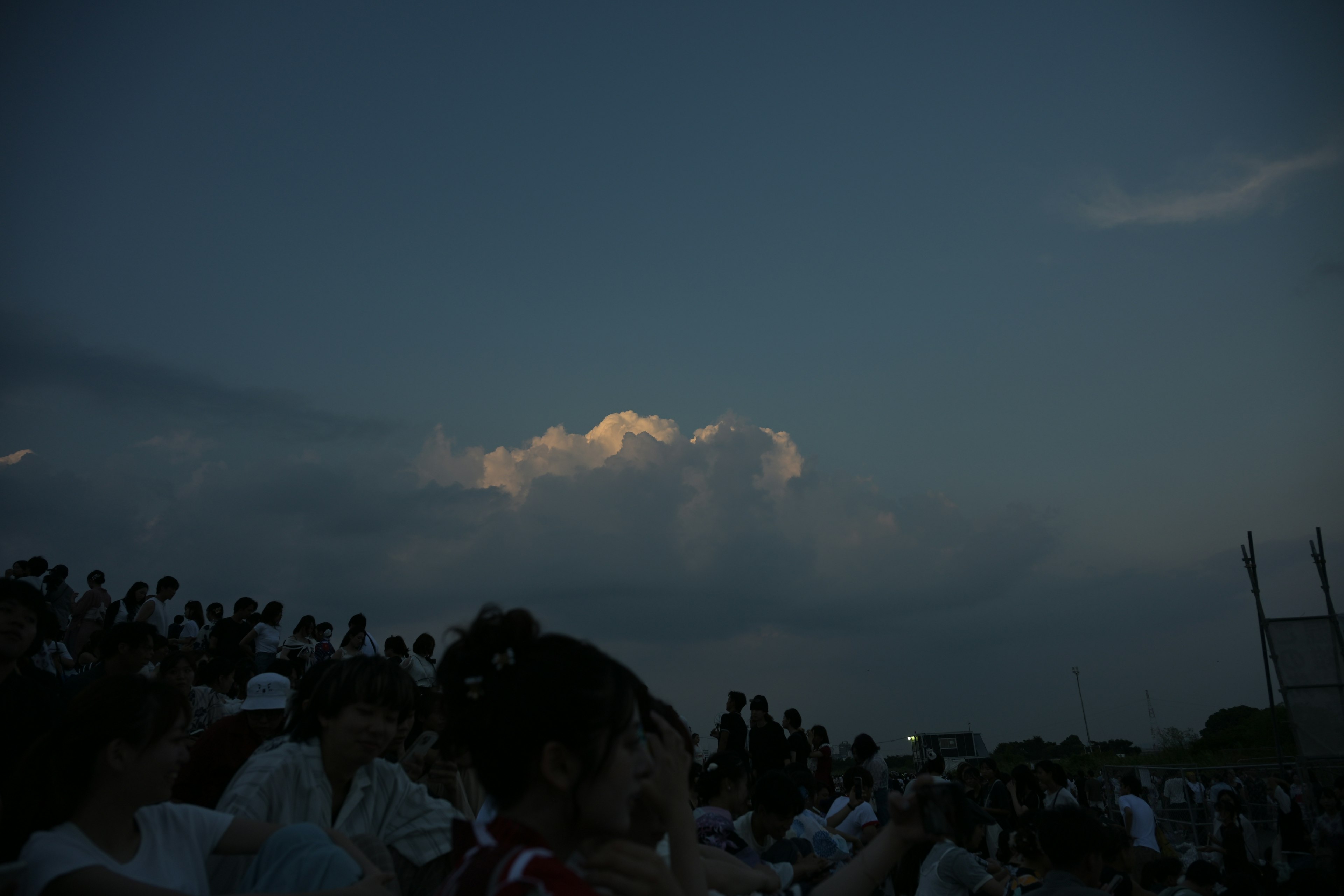 Cielo al tramonto con nuvole e silhouette di spettatori