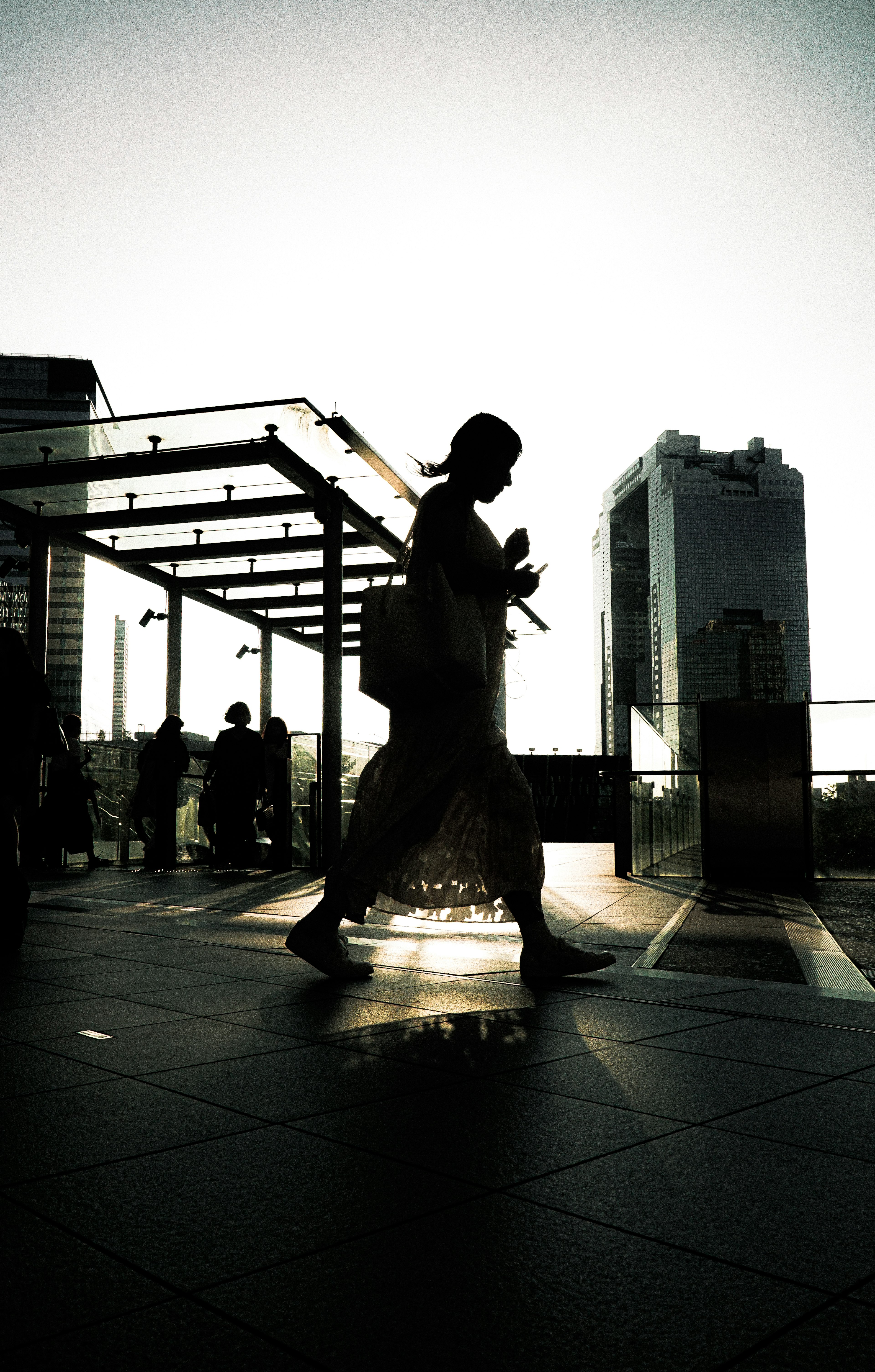 Silhouette of a person walking in an urban landscape