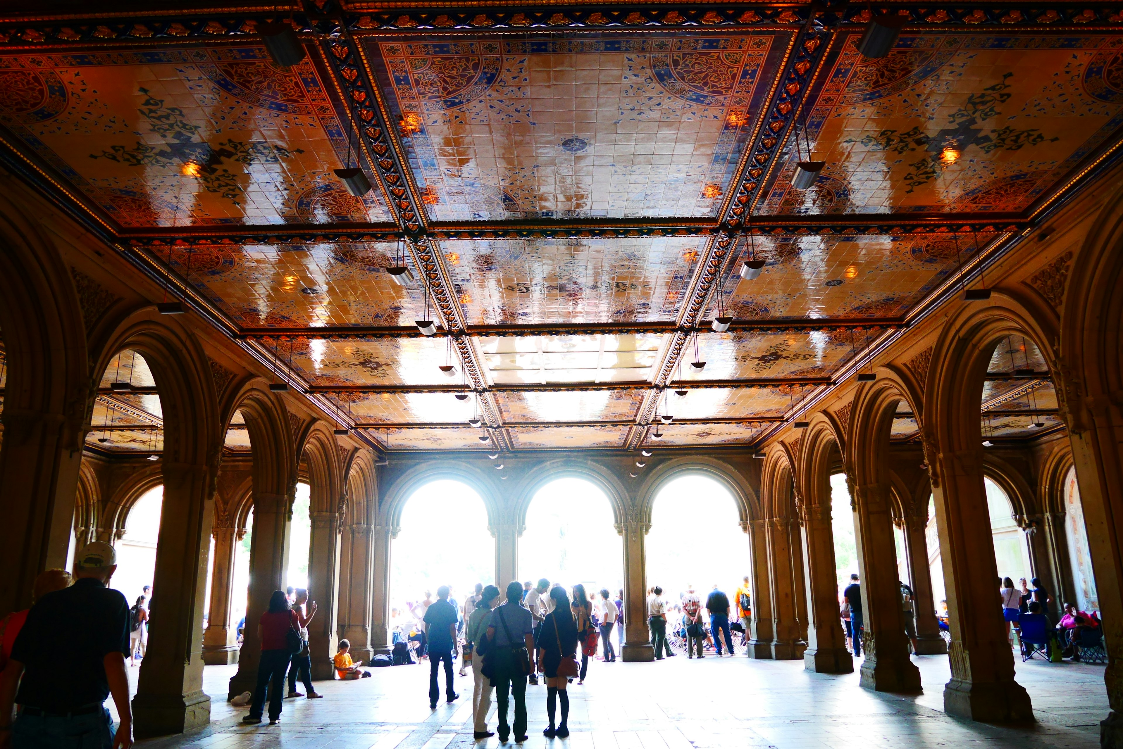 Kumpulan orang yang ramai di pavilion berbentuk lengkung dengan langit-langit dekoratif di Central Park