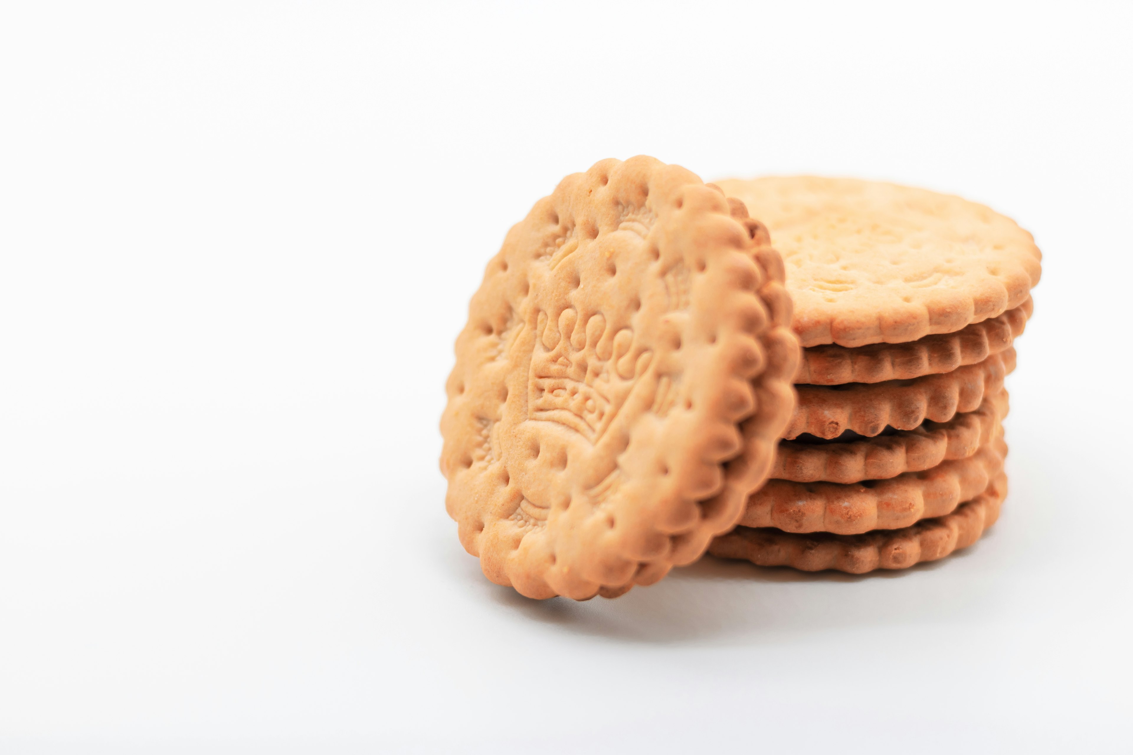 Empilement de biscuits nature avec un motif en relief sur un fond blanc