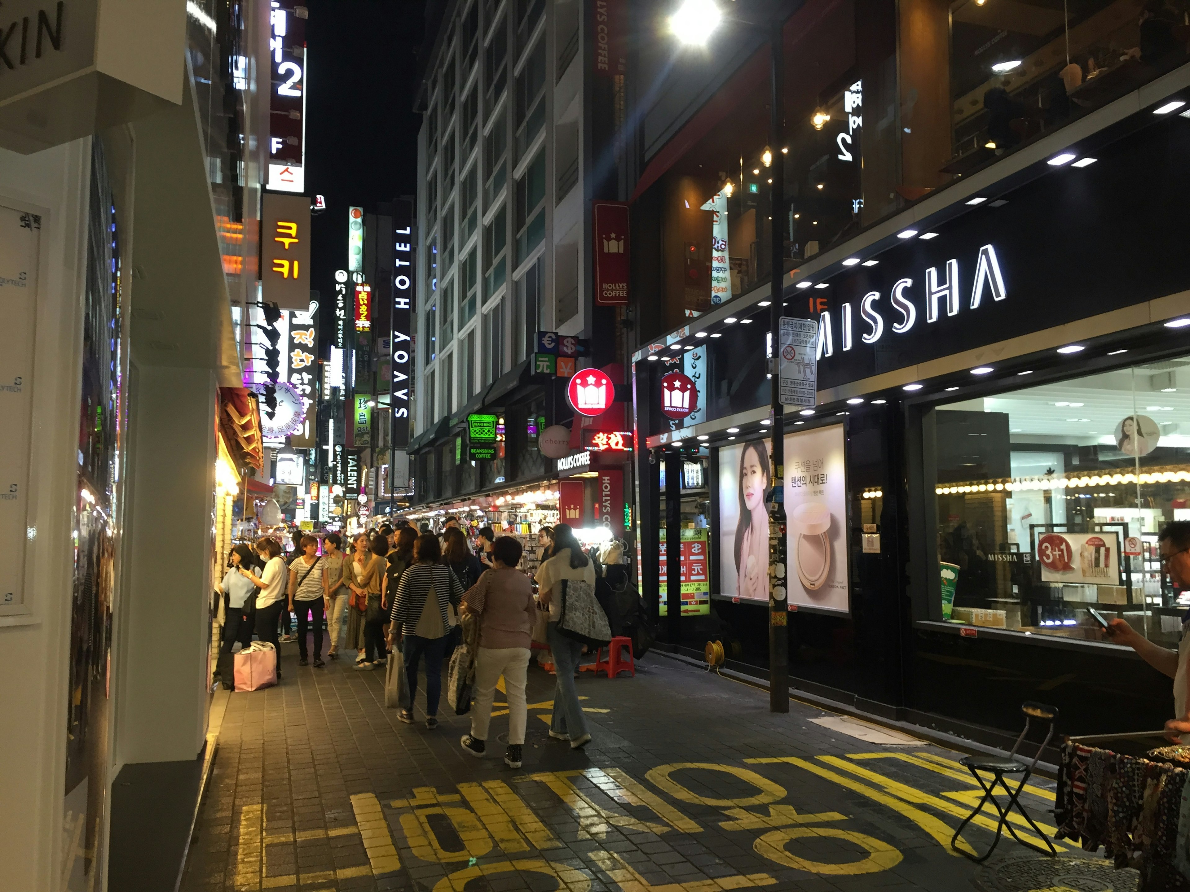 Busy night street with people and bright signage