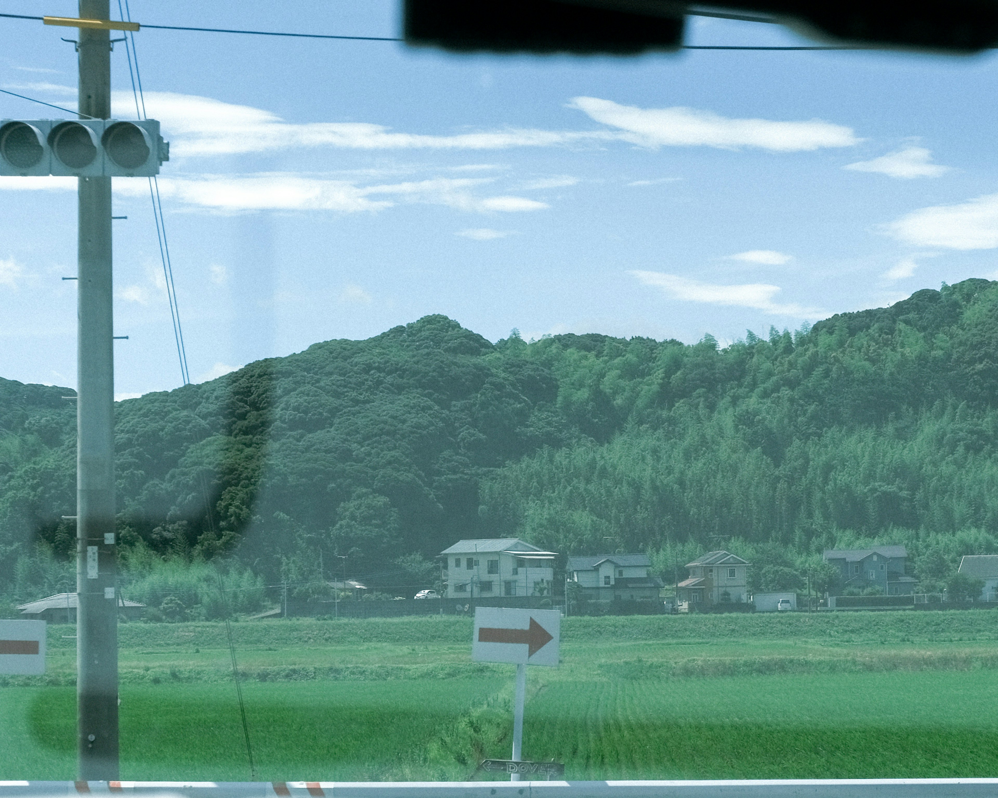 Rural landscape with houses and hills under a blue sky