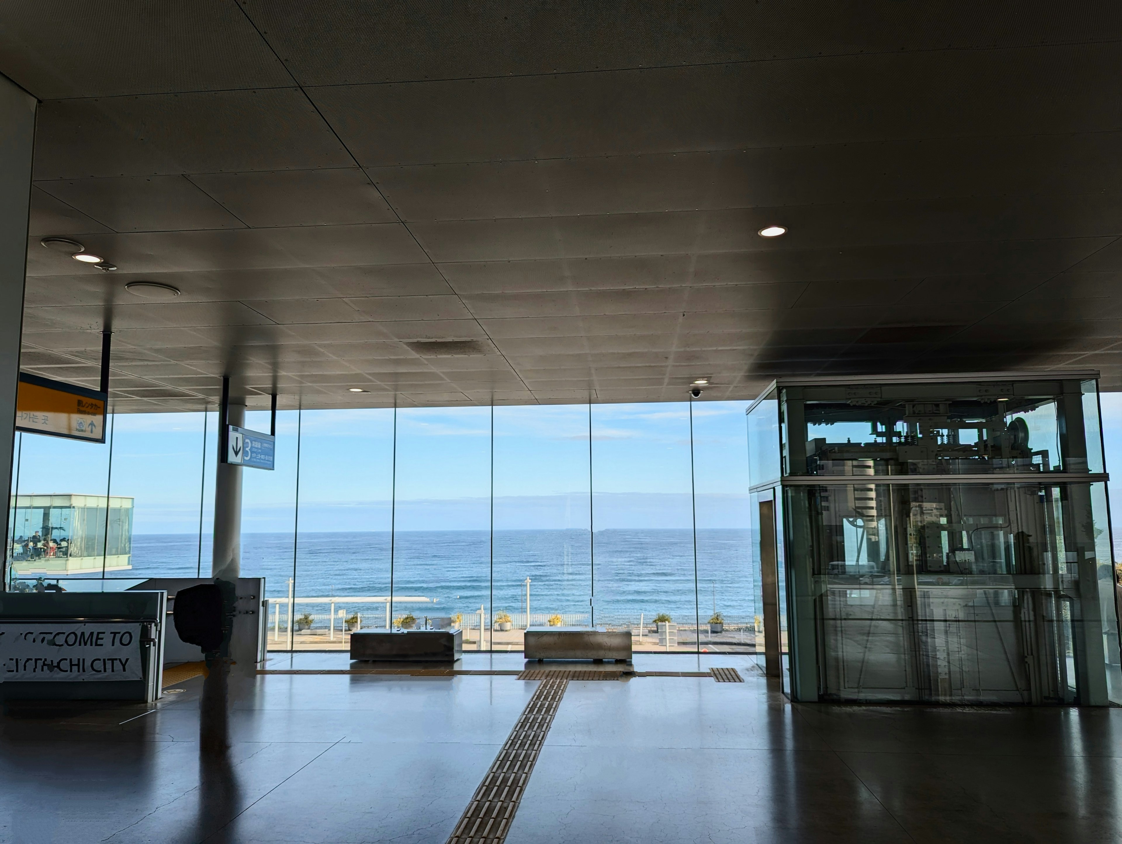 Interior view of a glass building overlooking the sea