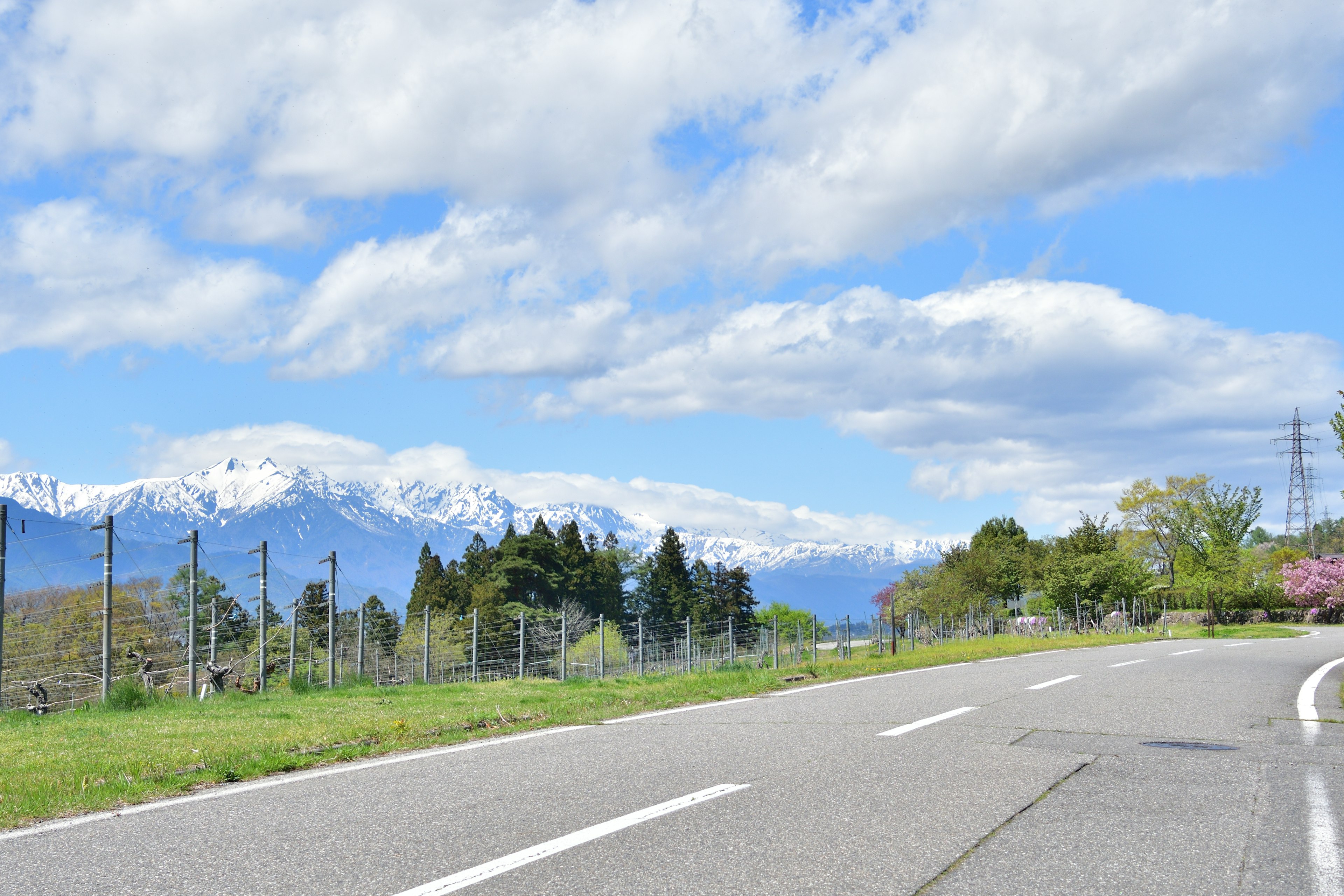 Landschaftsansicht einer Straße mit schneebedeckten Bergen und blauem Himmel