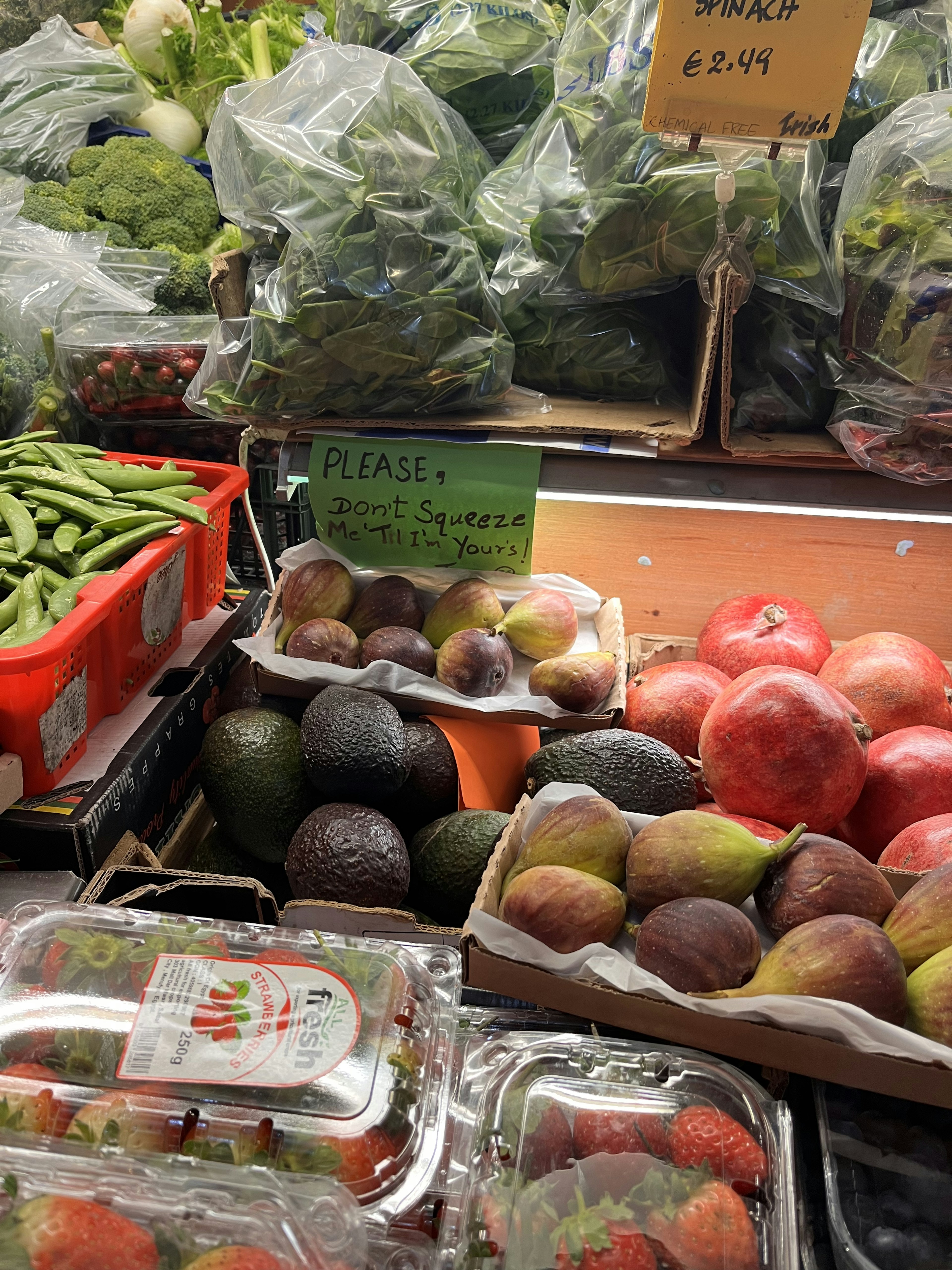 A vibrant display of fresh vegetables and fruits including avocados and strawberries