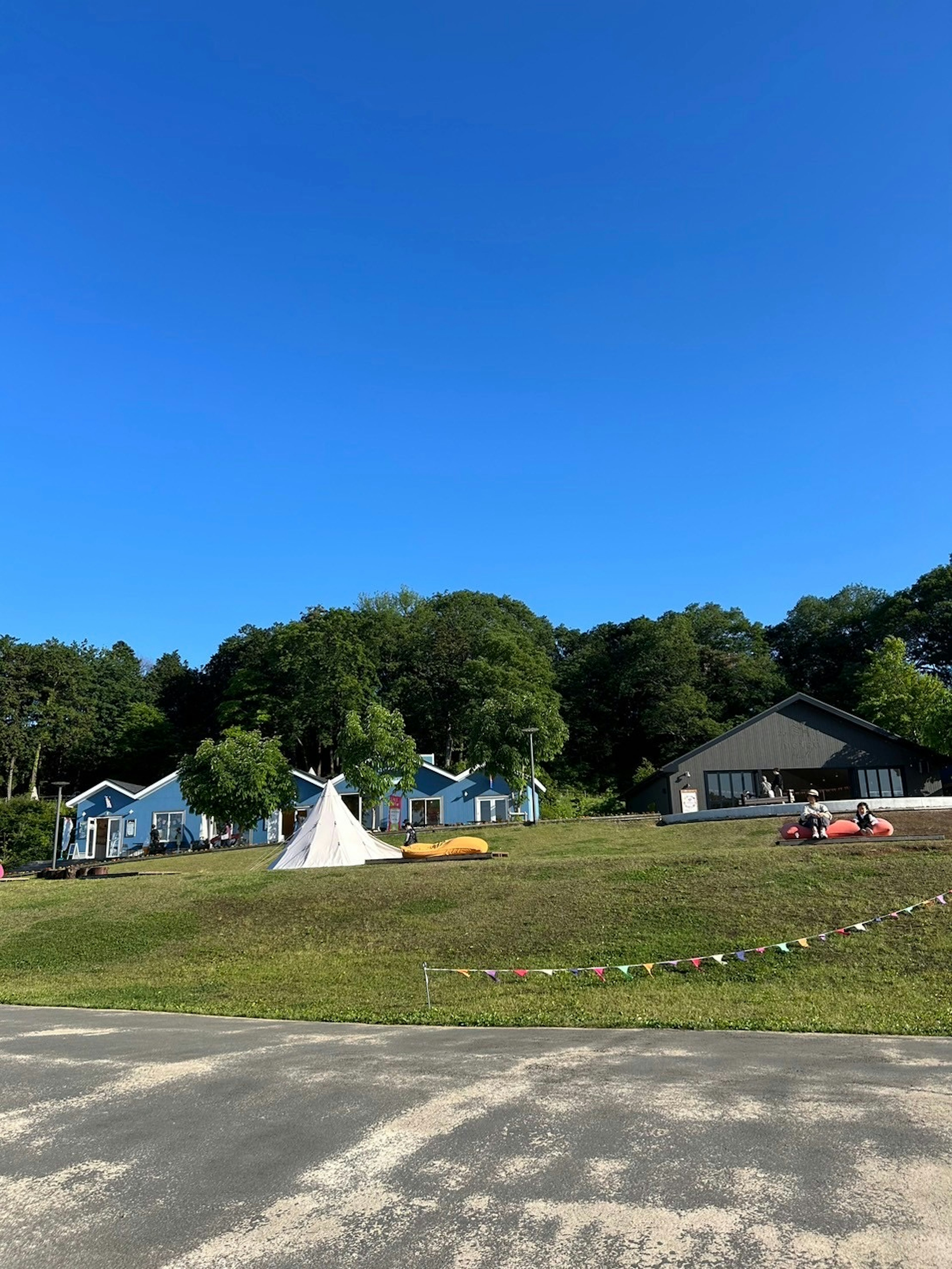 A landscape with colorful buildings and a tent under a blue sky