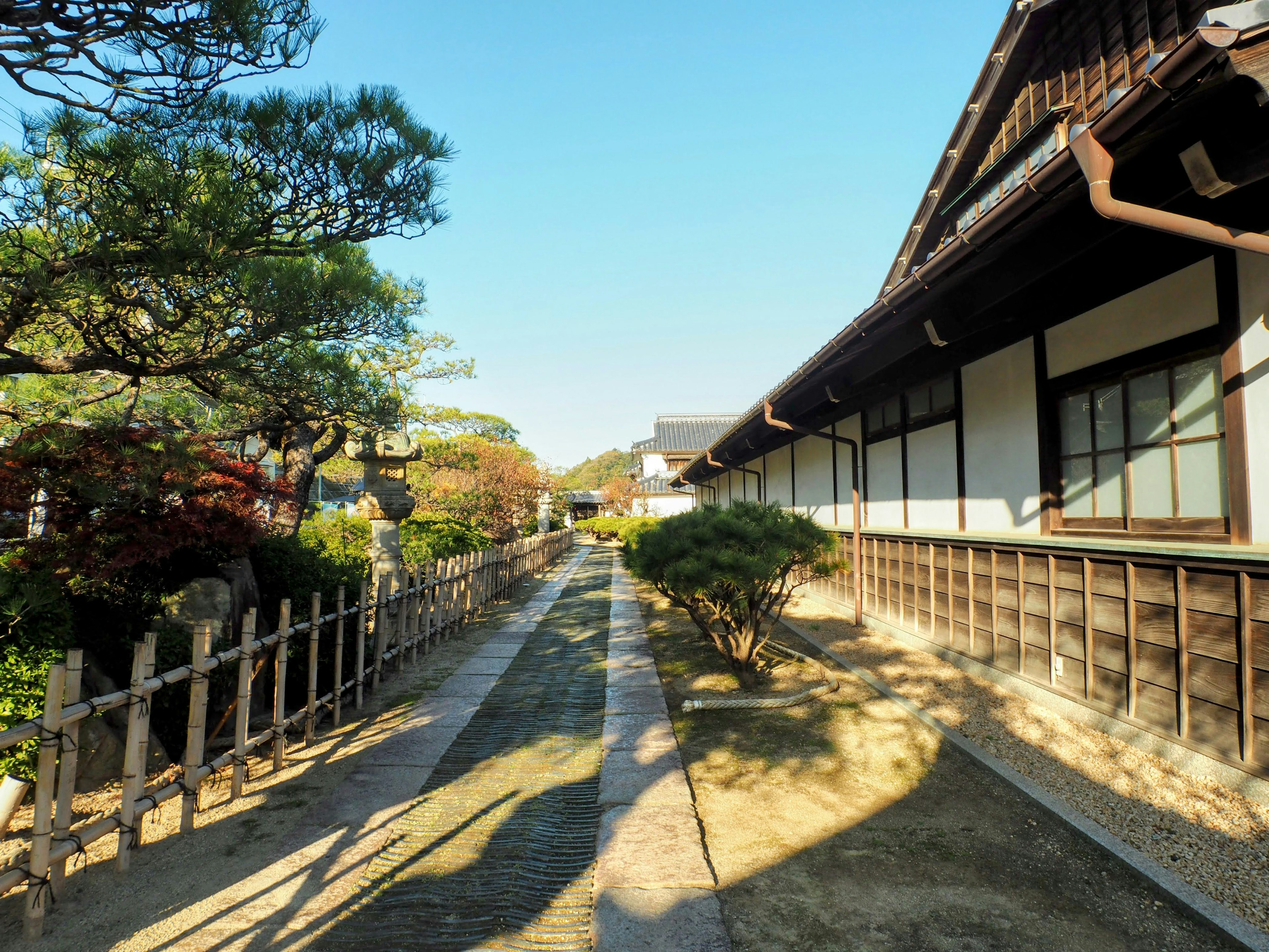 Serene Japanese garden pathway with traditional houses lining the sides