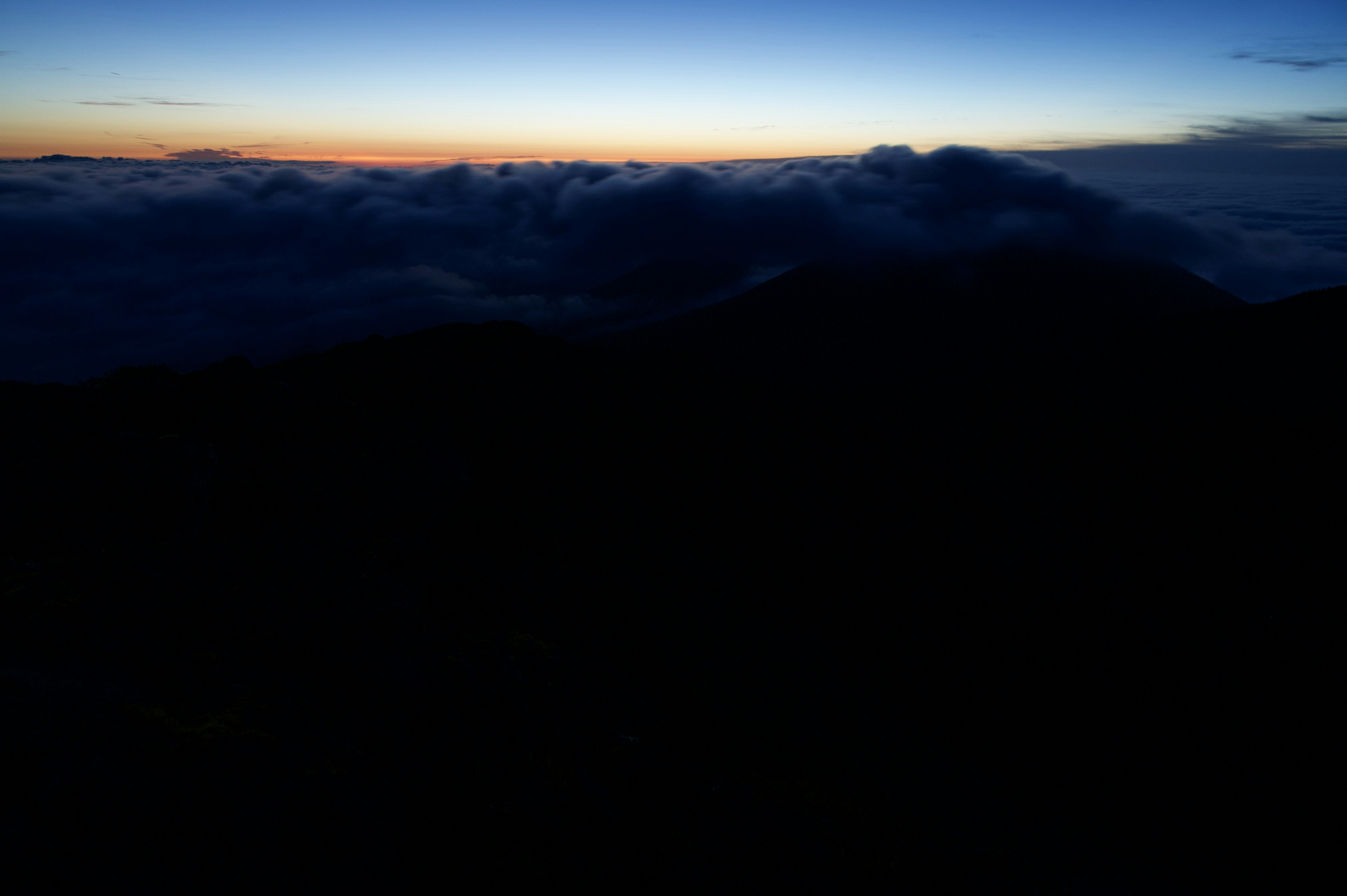 山の上からの美しい夕焼けの風景に雲が広がる