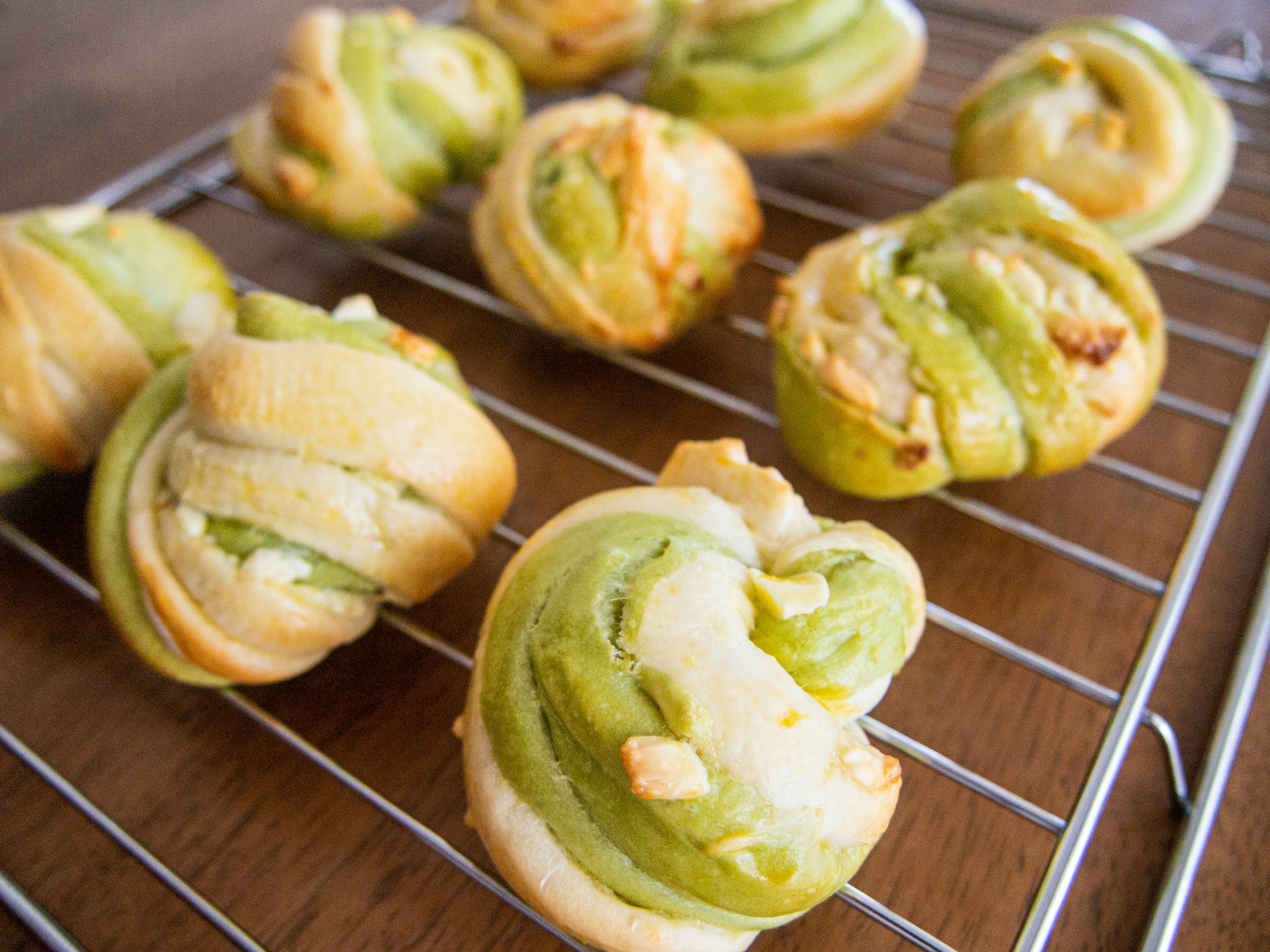 Gebackene Gebäckstücke mit grüner Creme auf einem Gitter angeordnet