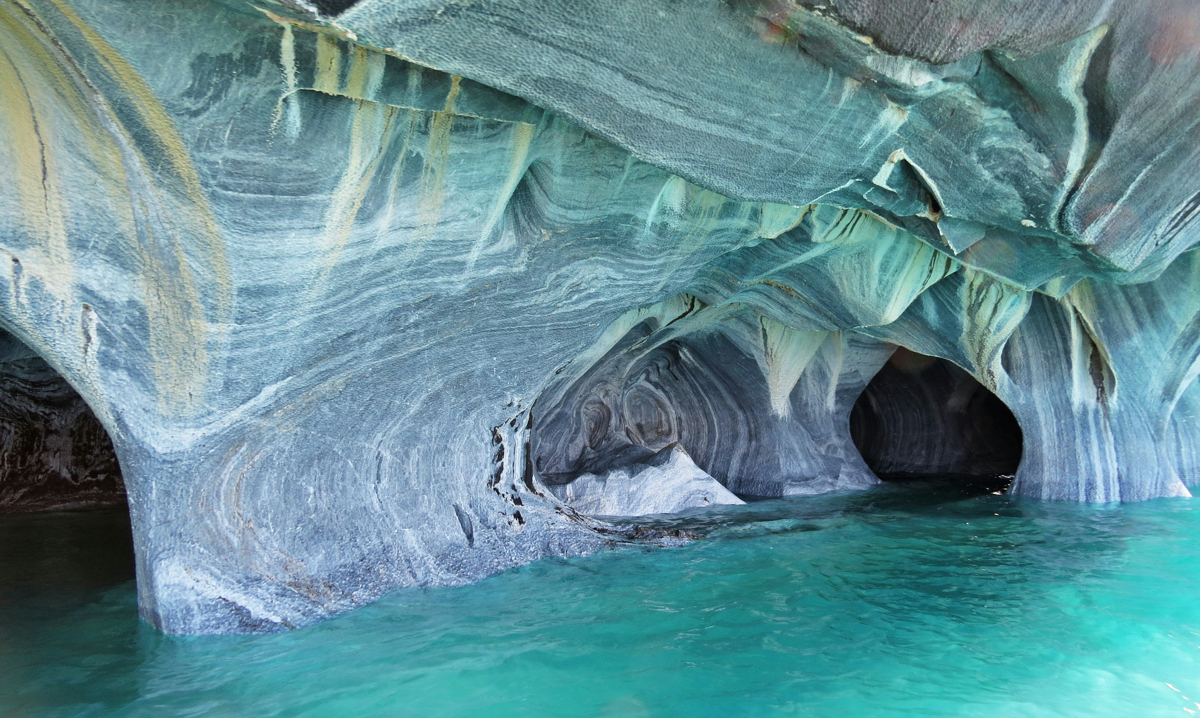 Inneres einer Marmorhöhle umgeben von wunderschönem blauem Wasser