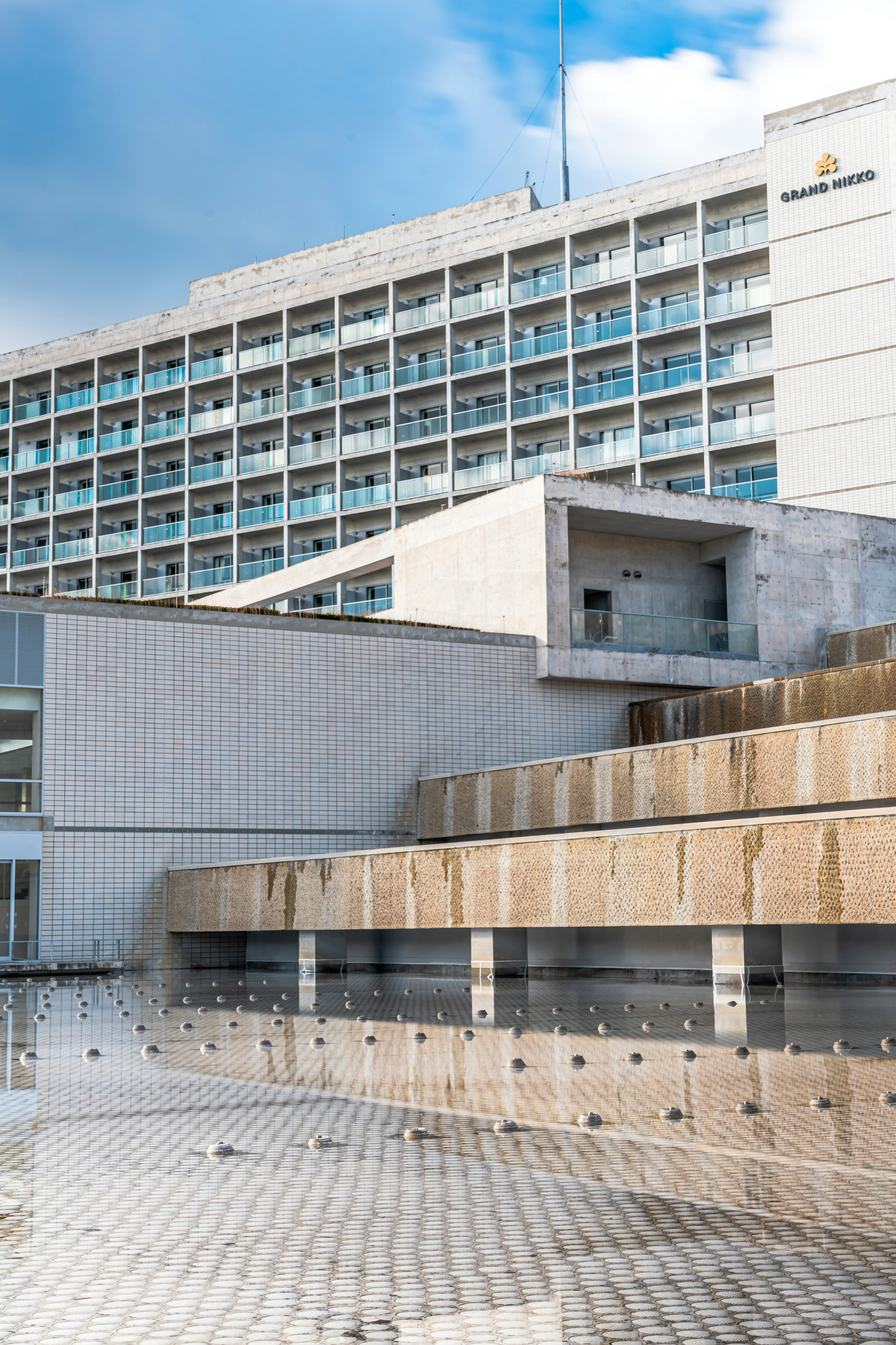 Exterior moderno de un hotel con elementos arquitectónicos y características de agua