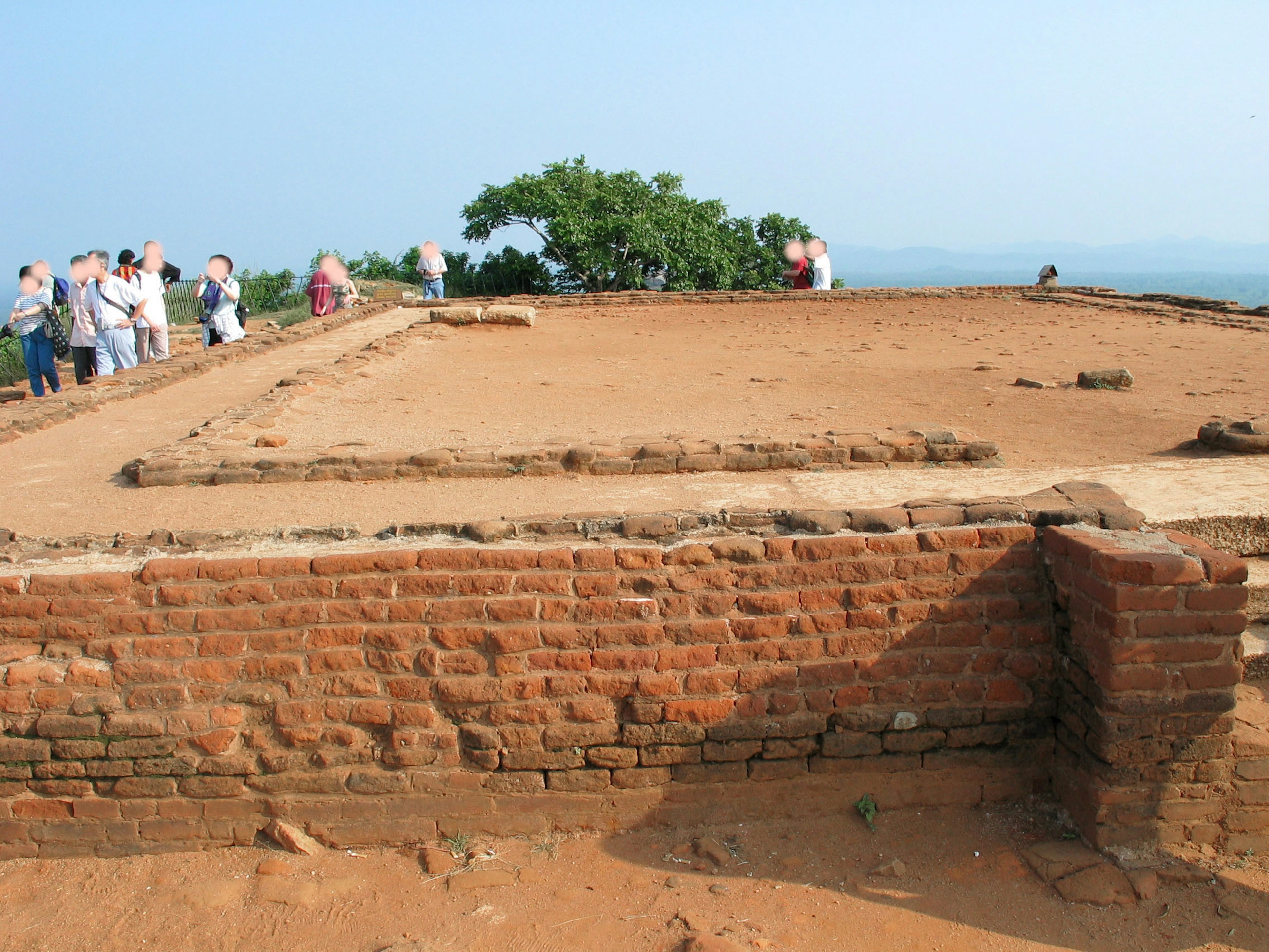 Tourists at the site of an ancient ruin with brick foundations