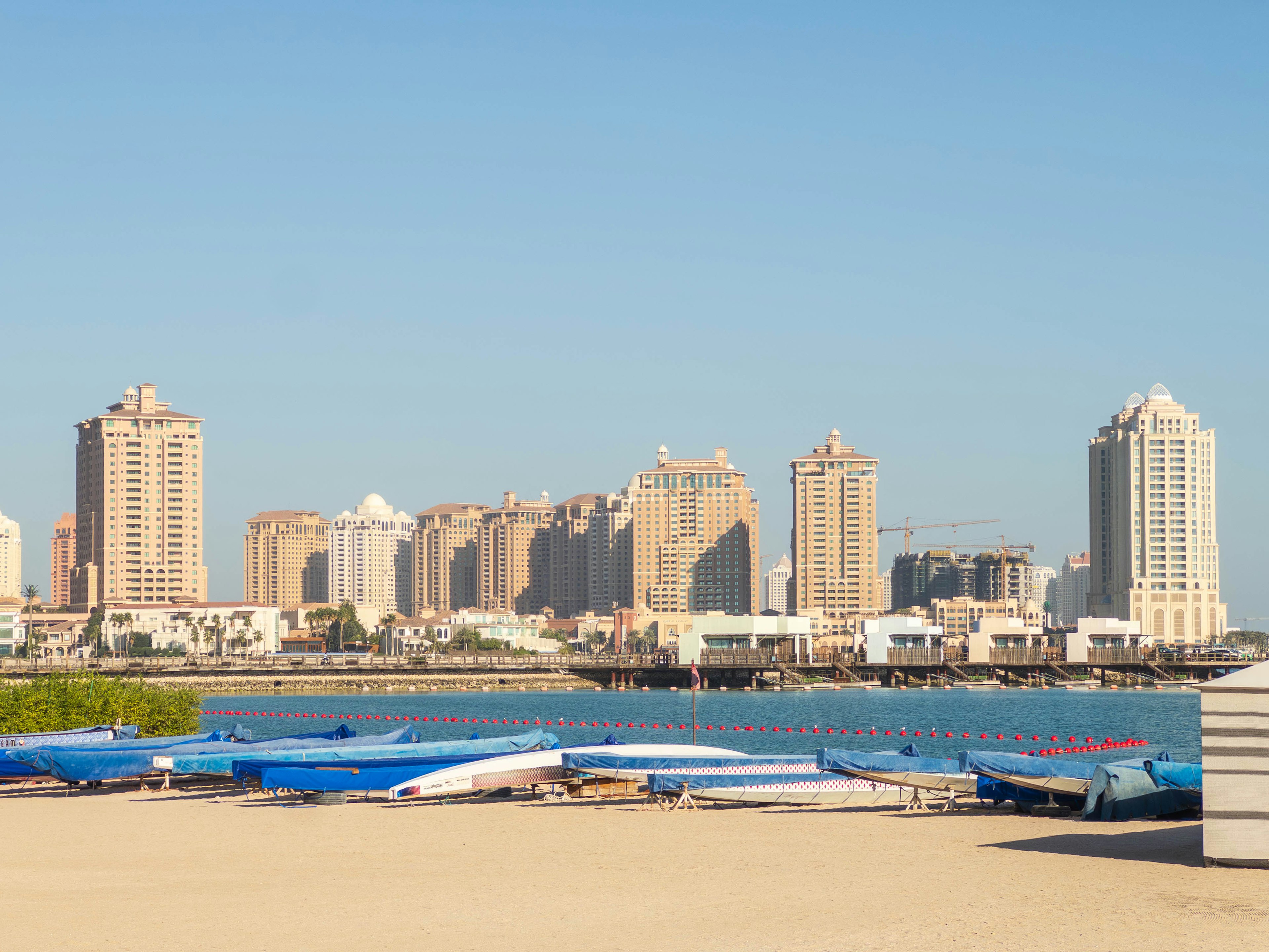 Scenic view of blue boats lined up with skyscrapers in the background