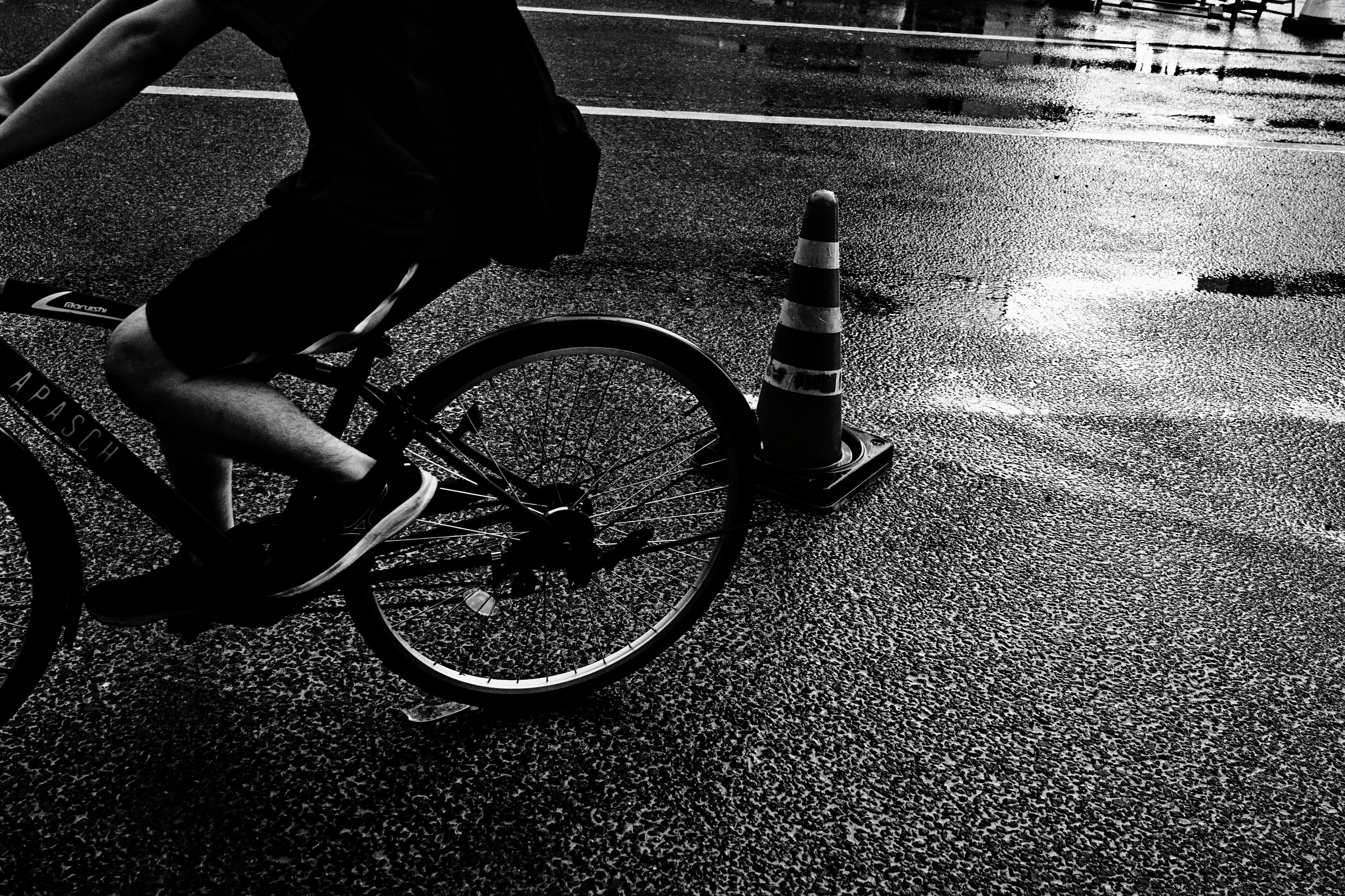 自転車に乗る人の脚と車輪が写っている夜の街の風景