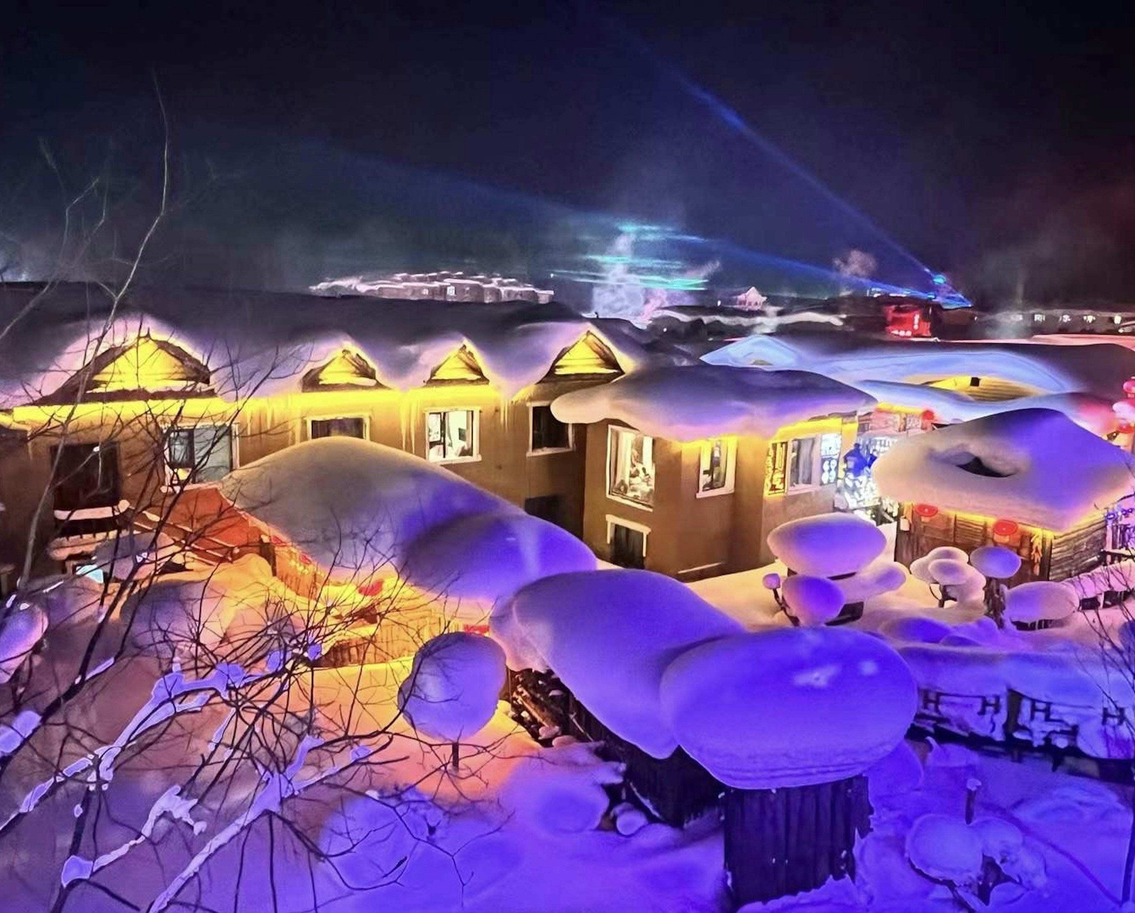 Edificios cubiertos de nieve iluminados por luces de colores por la noche