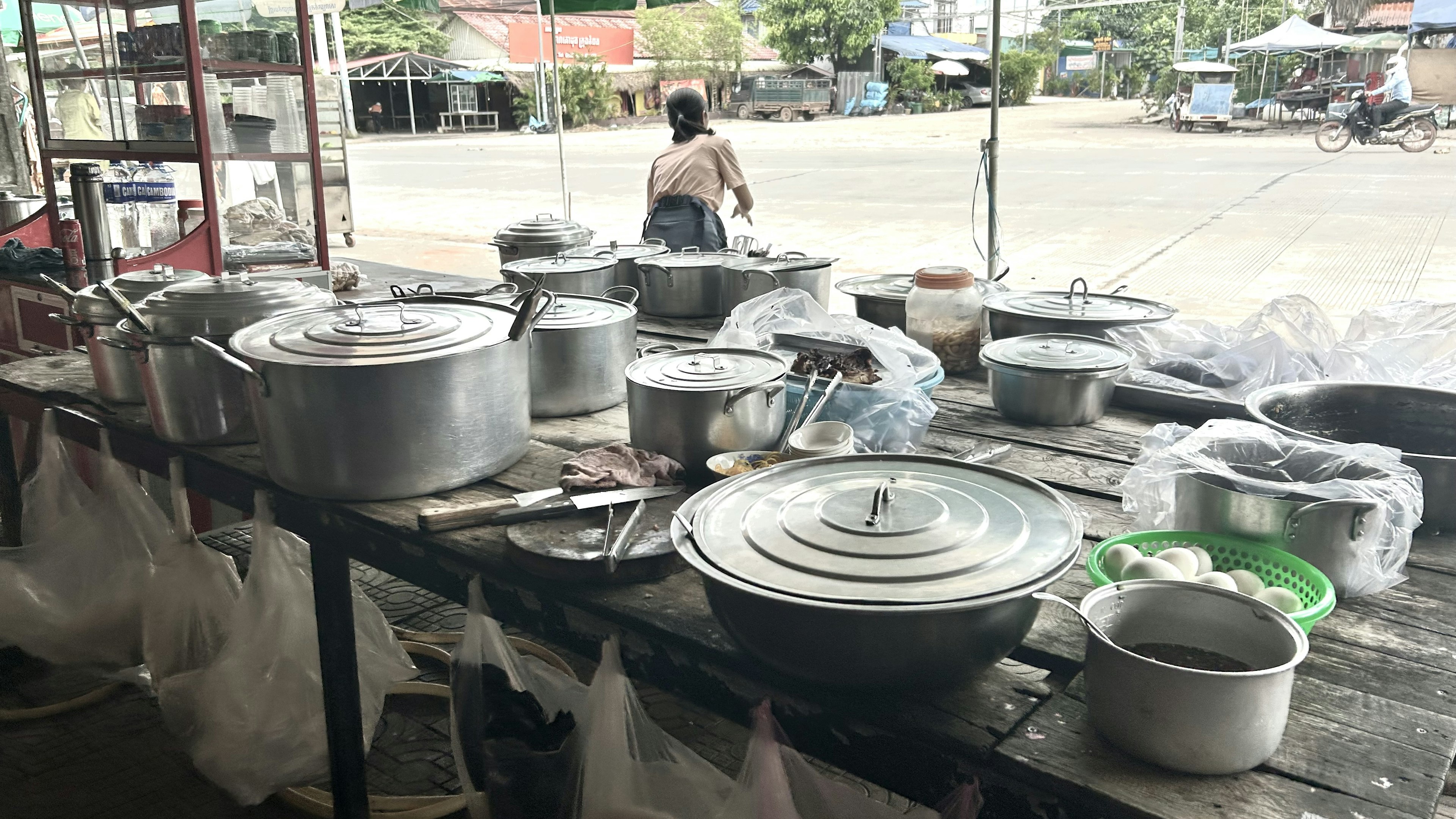 Un stand de rue avec divers pots de cuisson et ustensiles