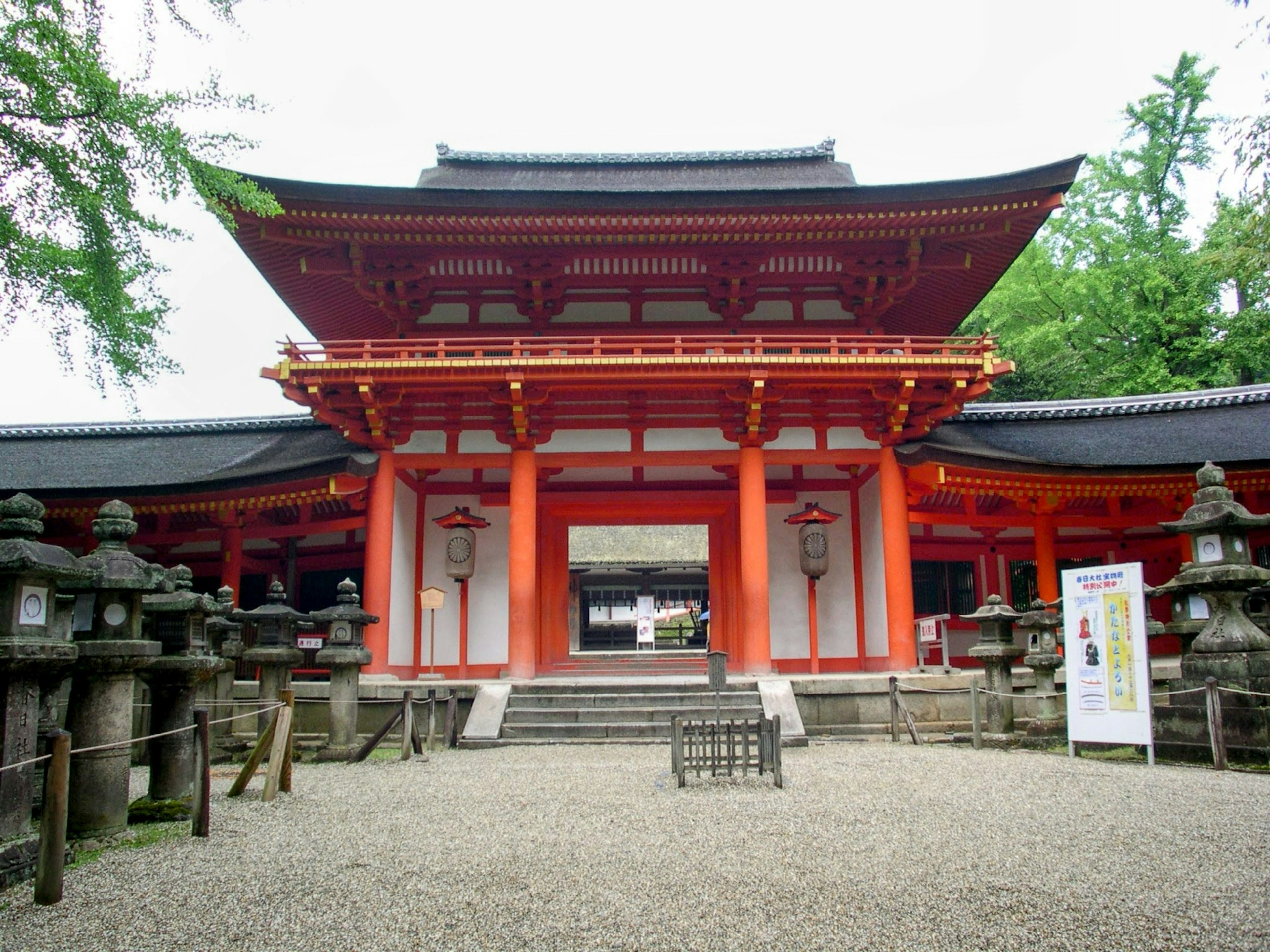 Entrance of a shrine featuring a red gate and stone lanterns